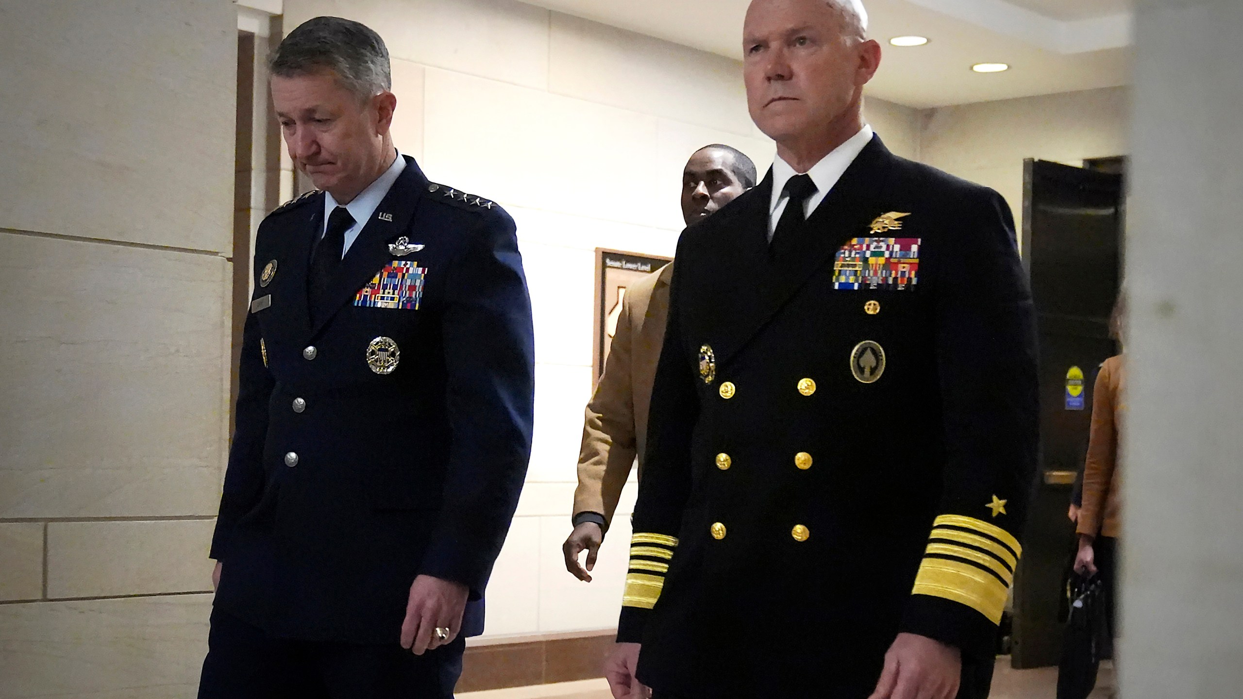 U.S. Navy Adm. Frank M. Bradley, right, accompanied by Gen. Dan Caine, chairman of the Joint Chiefs of Staff, left, walks to a meeting with senators on Capitol Hill, Thursday, Dec. 4, 2025, in Washington. (AP Photo/Mark Schiefelbein)