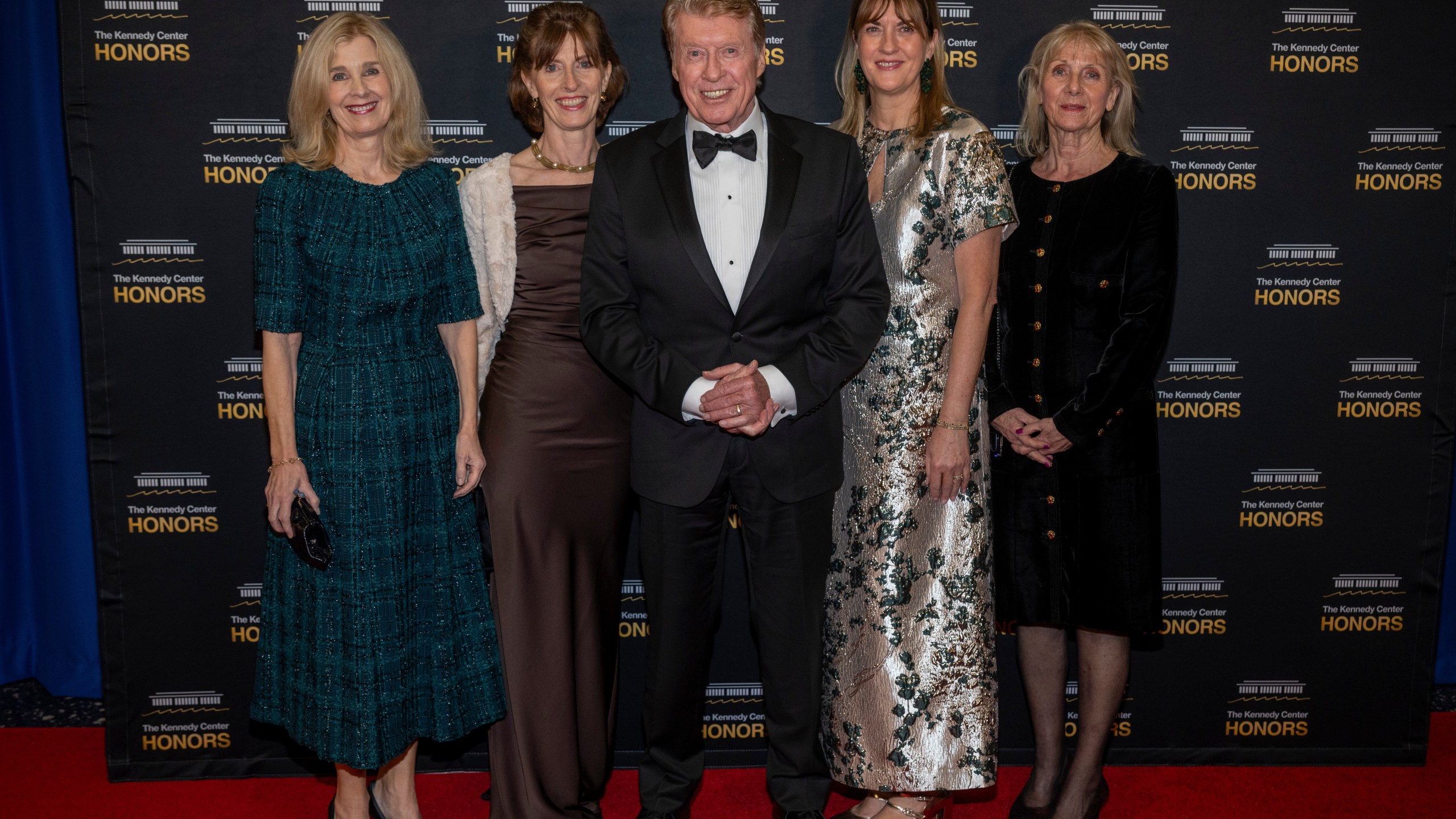 2025 Kennedy Center Honoree Michael Crawford, center, and his family arrive on the red carpet for the 48th Kennedy Center Honors Medallion Reception, hosted at the U.S. Department of State, Saturday, Dec. 6, 2025 in Washington. (AP Photo/Kevin Wolf)