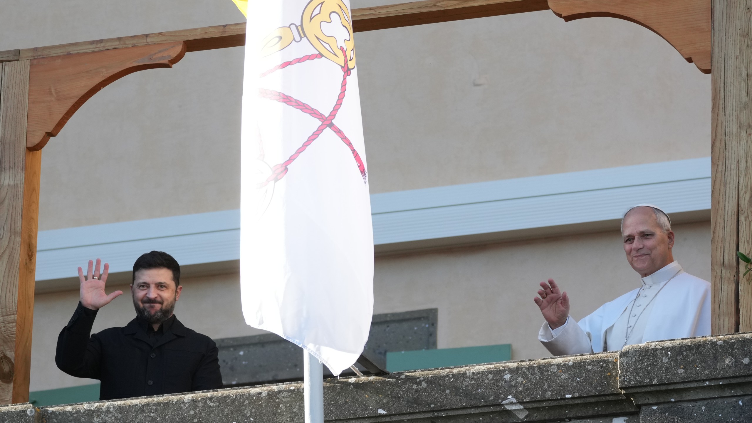 Ukraine's President Volodymyr Zelenskyy and Pope Leo XIV wave to journalists during their meeting in Castel Gandolfo, Italy, Tuesday, Dec. 9, 2025. (AP Photo/Andrew Medichini)