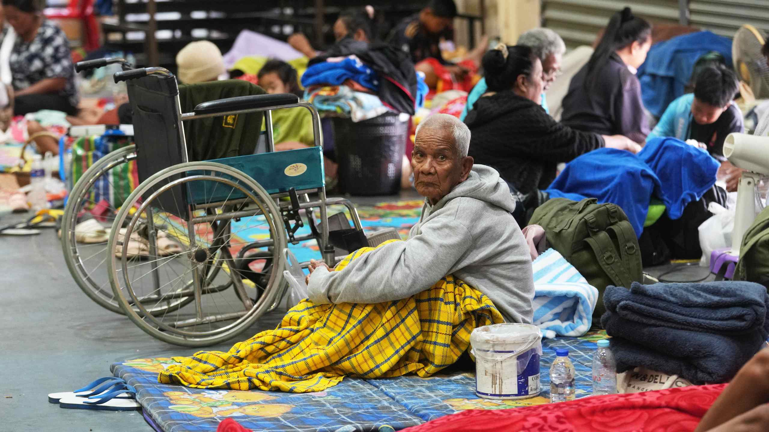 Thai residents who fled homes following the clashes between Thai and Cambodian soldiers, rest at an evacuation center in Surin province, Thailand, Wednesday, Dec. 10, 2025. (AP Photo/Sakchai Lalit)