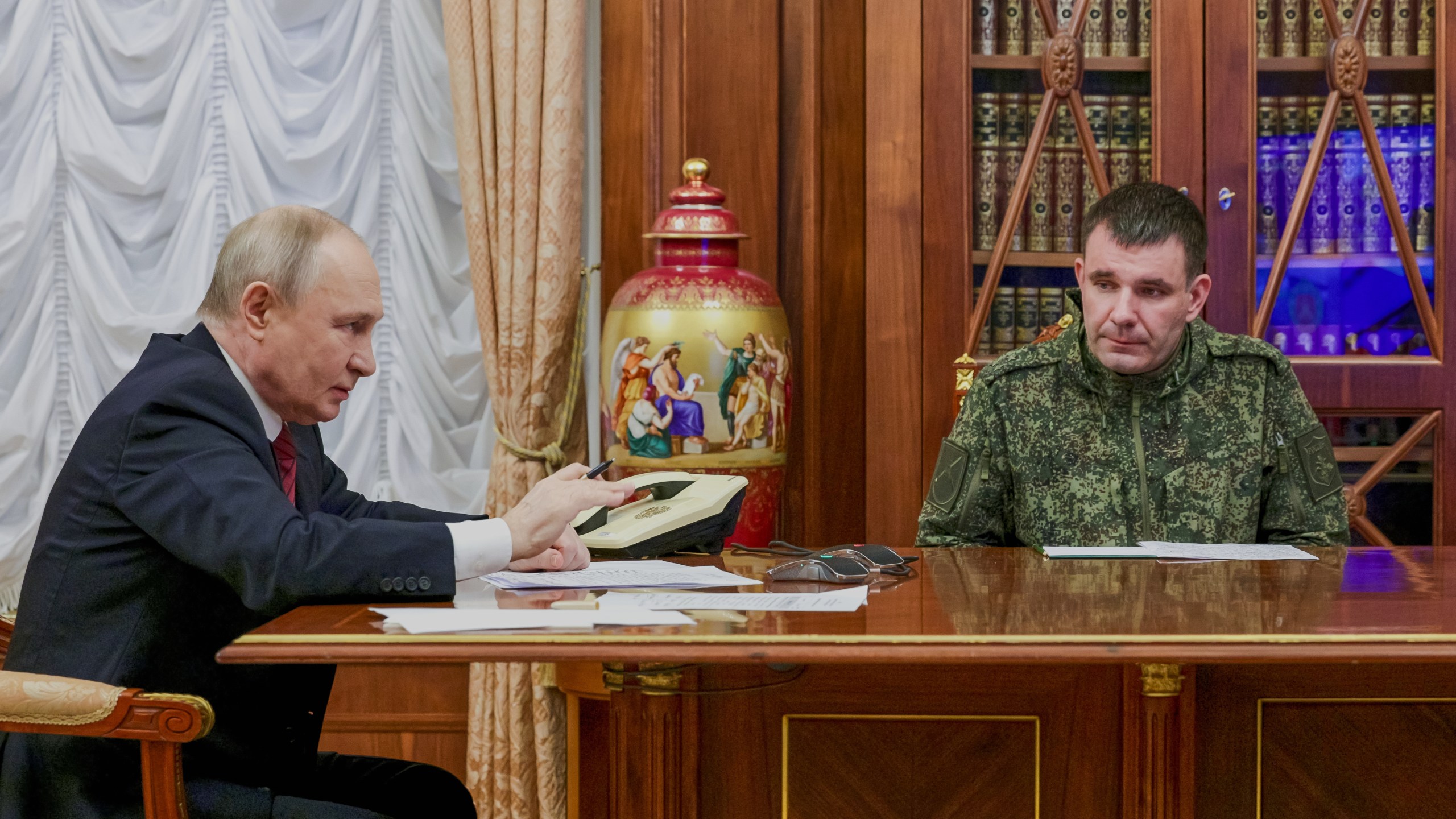 Russian President Vladimir Putin, left, holds a call with military leaders on the Ukraine battlefield situation together with Denis Pirogov, right, a Russian army brigade commander, at the Kremlin in Moscow, on Thursday, Dec. 11, 2025. (Gavriil Grigorov, Sputnik, Kremlin Pool Photo via AP)