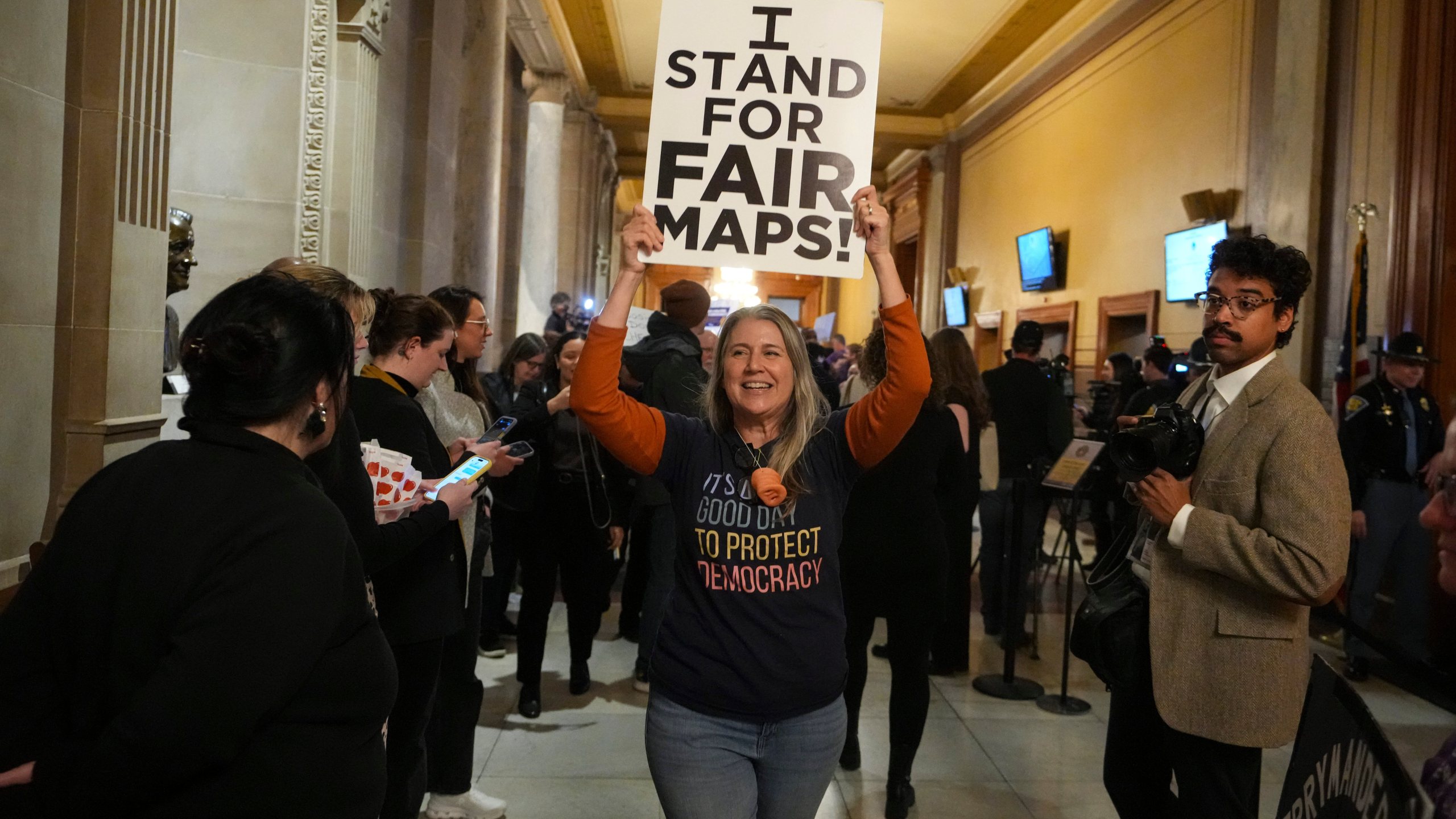 A protester celebrates as they walk outside the Indiana Senate Chamber after a bill to redistrict the state's congressional map was defeated, Thursday, Dec. 11, 2025, at the Statehouse in Indianapolis. (AP Photo/Michael Conroy)