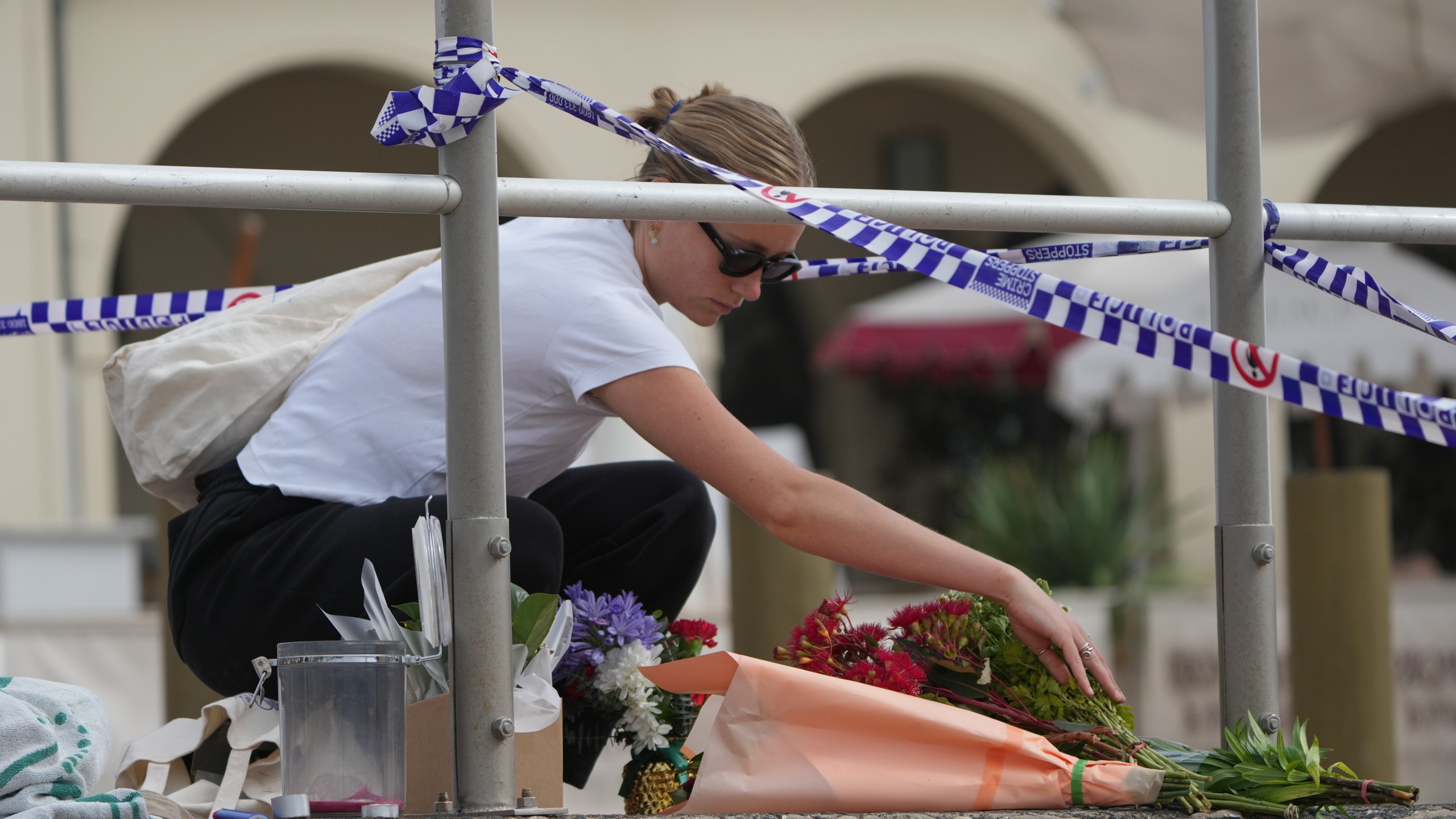 Shenna McClean lays flowers at a memorial at Sydney's Bondi Beach, Monday, Dec. 15, 2025, a day after a shooting. (AP Photo/Mark Baker)
