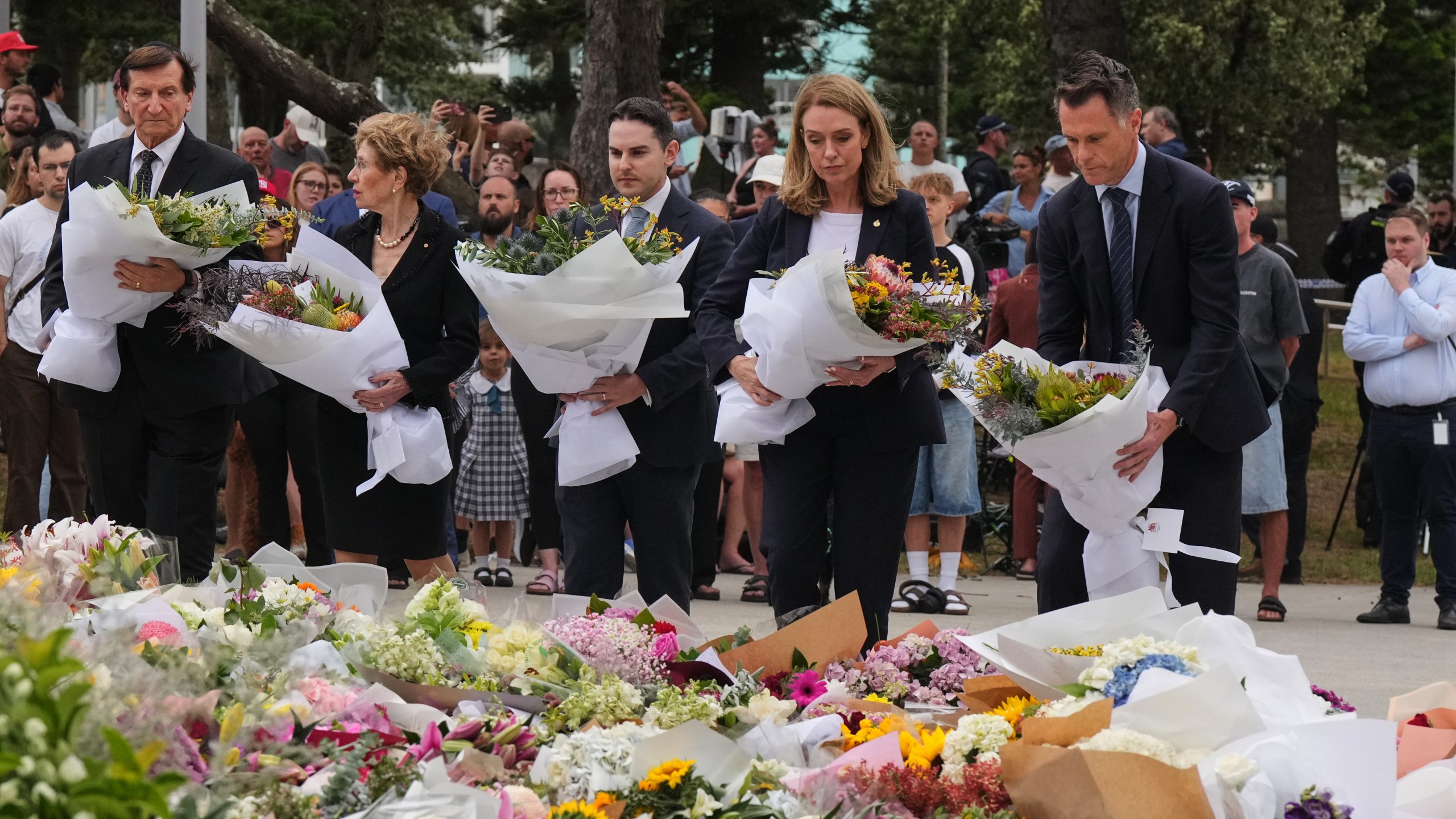 New South Wales Premier Chris Minns, right, and Kellie Sloane, leader of the opposition, the New South Wales Liberal Party, lay wreaths at a tribute for shooting victims outside the Bondi Pavilion at Sydney's Bondi Beach, Monday, Dec. 15, 2025, a day after a shooting. (AP Photo/Mark Baker)