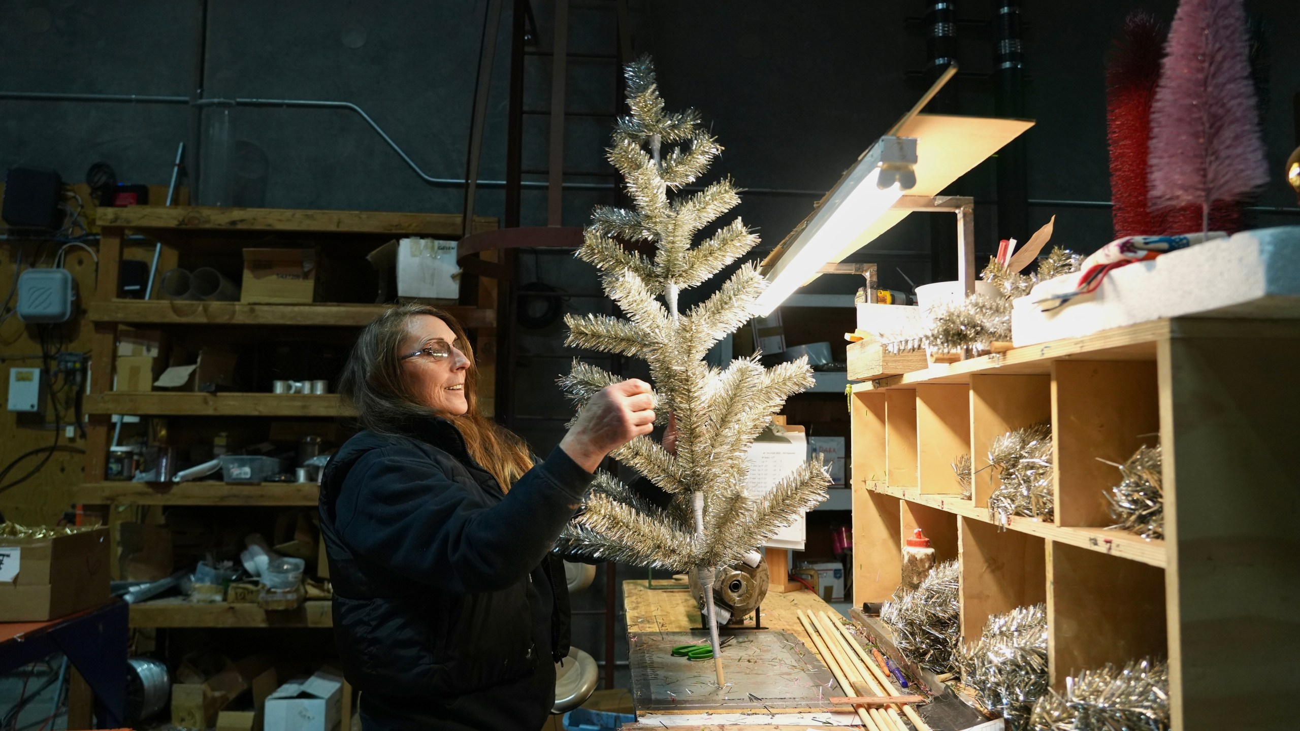 Melissa Webb assembles an artificial Christmas tree at Lee Display's warehouse, in Fairfield, Calif., Tuesday, Dec. 9, 2025. (AP Photo/Terry Chea)