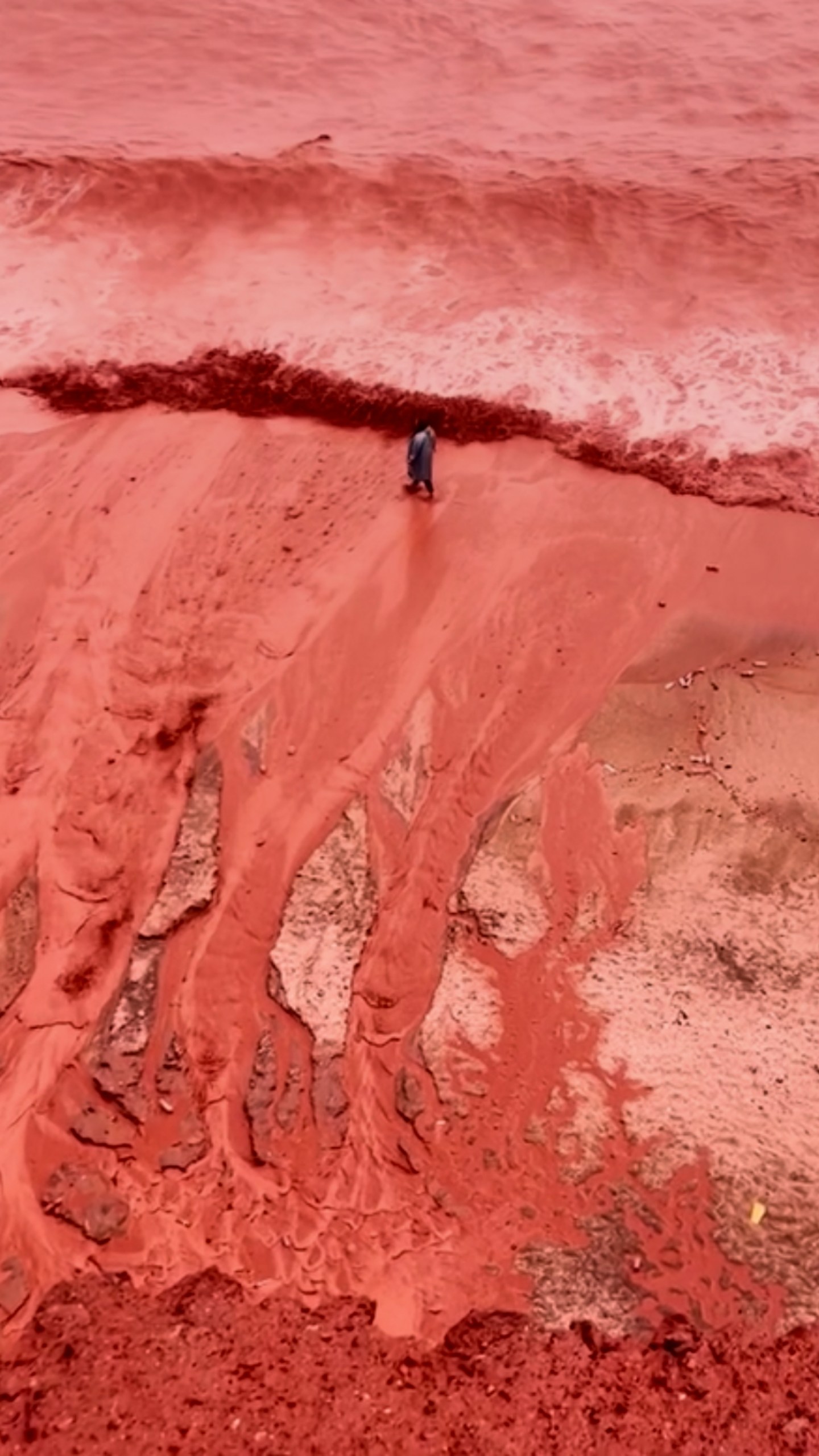 This picture, taken from video, shows how rainfall briefly transforms the coastline of its famed Red Beach into a striking natural scene on Iran's Hormuz Island, Tuesday Dec. 16, 2025. (AP Photo)