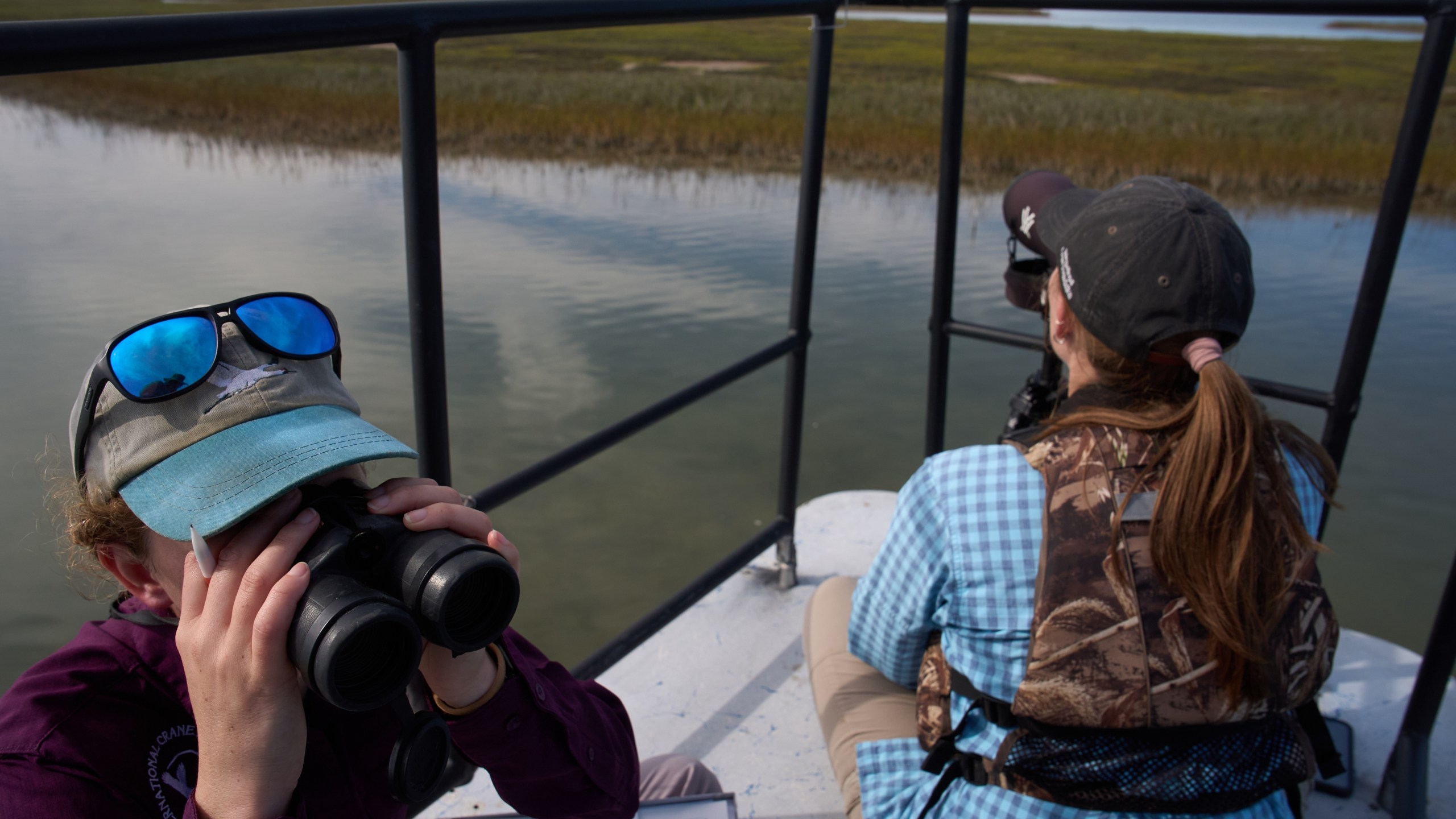 Katie Fernald, Wetland/Rangeland Ecologist, International Crane Foundation, left, and Matti Bradshaw, Leiden Whooping Crane Biologist, International Crane Foundation, study whooping cranes, Friday, Dec. 12, 2025, near Rockport, Texas. (AP Photo/John Locher)