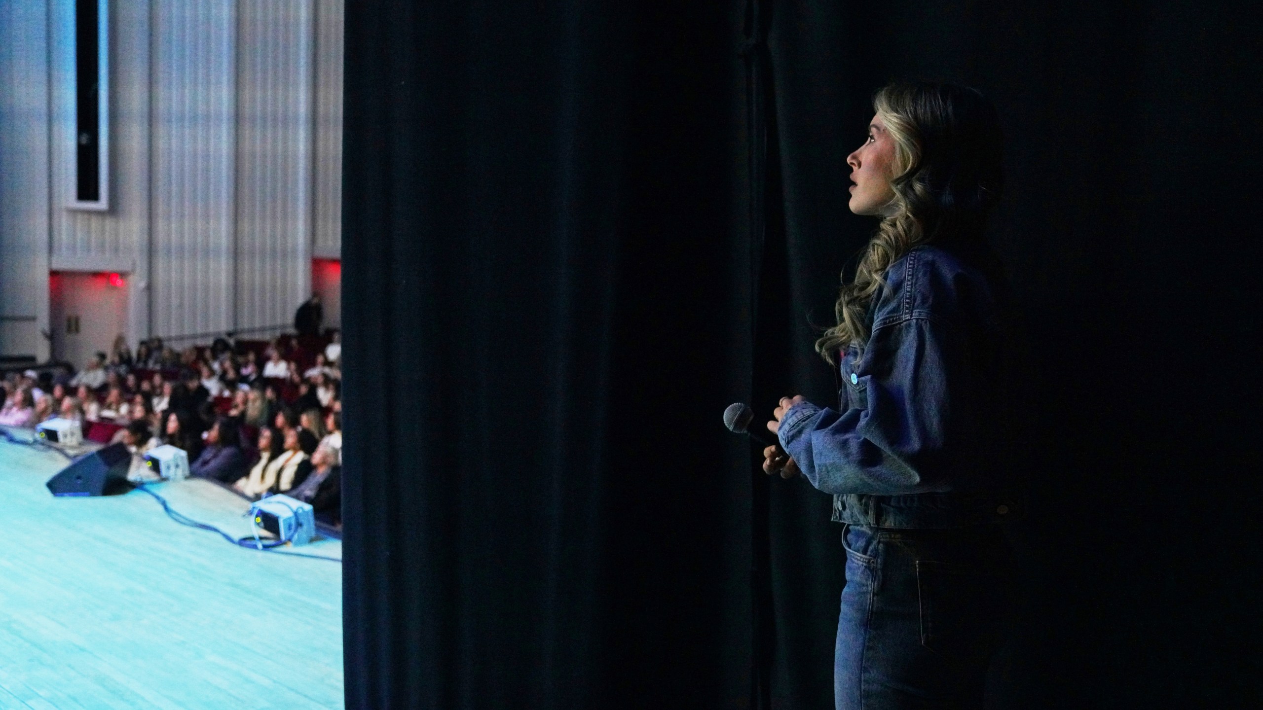 Angela Halili, 29, cohost of the Christian podcast, "Girls Gone Bible," stands backstage before their live show as fans and followers sing worship music in the Atlanta Symphony Hall, Friday, Nov. 14, 2025, in Atlanta. (AP Photo/Jessie Wardarski)