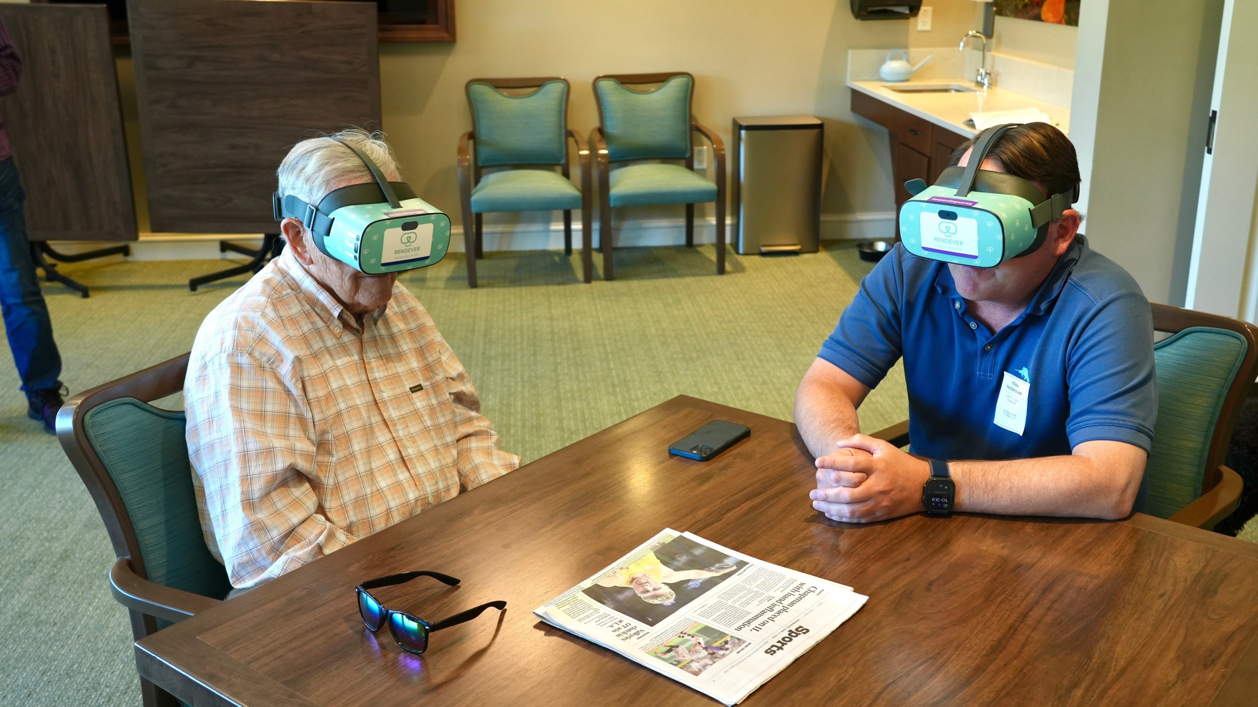 Jim Holtshouse and his son, Mike Holtshouse, watch video through Rendever virtual-reality headsets at the Forum at Rancho San Antonio retirement community in Cupertino, Calif. on June 11, 2025. (AP Photo/Terry Chea)