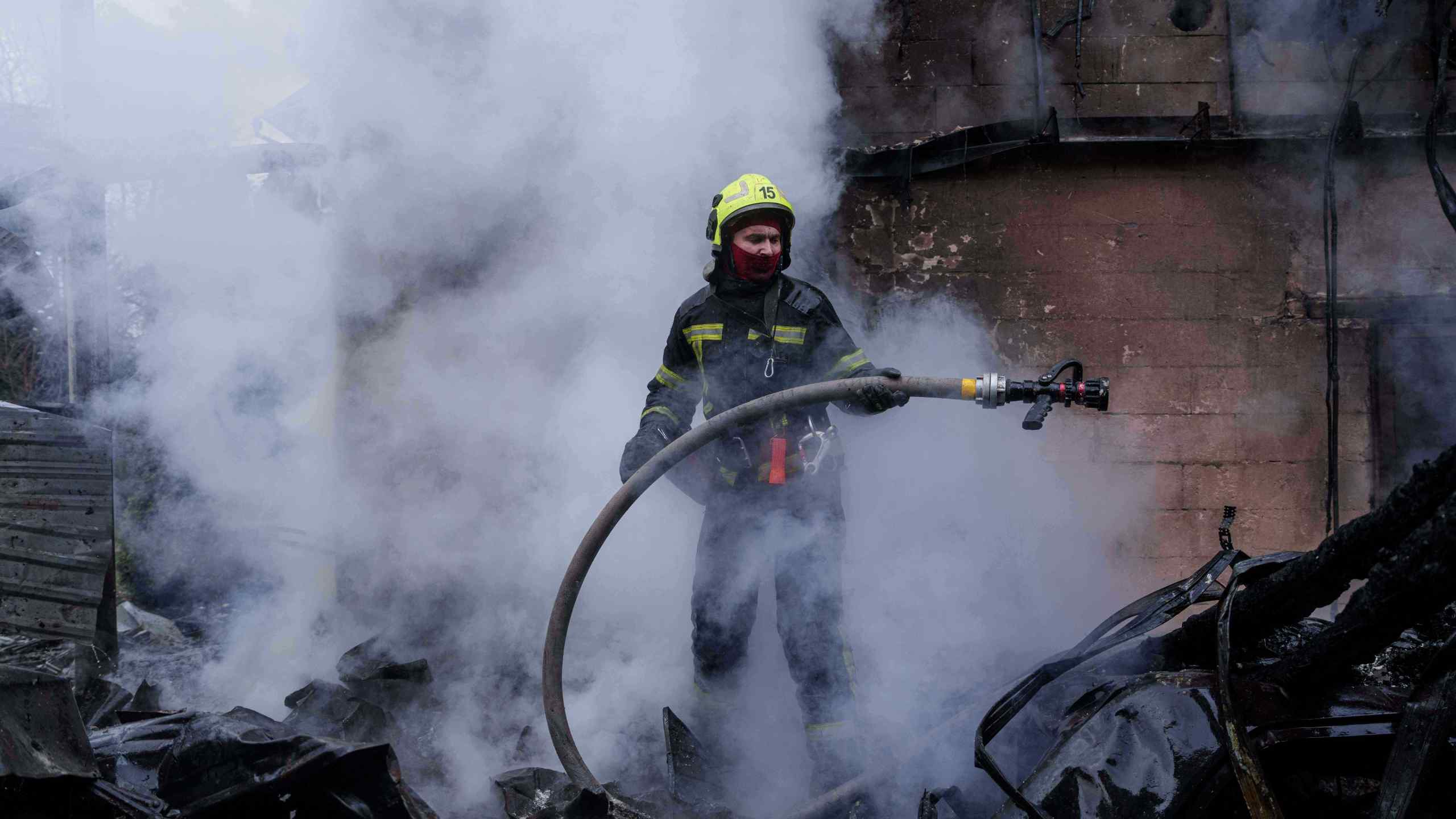 A rescue worker puts out a fire of a house destroyed after a Russian strike on Kyiv, Ukraine, on Saturday, Dec. 27, 2025. (AP Photo/Evgeniy Maloletka)
