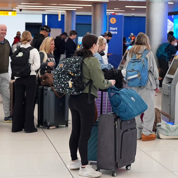 travelers lining up inside an airport