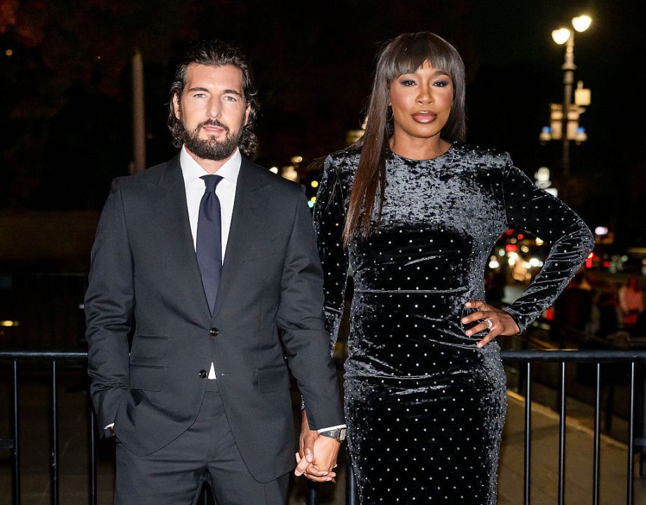Andrea Preti and Venus Williams holding hands in all black