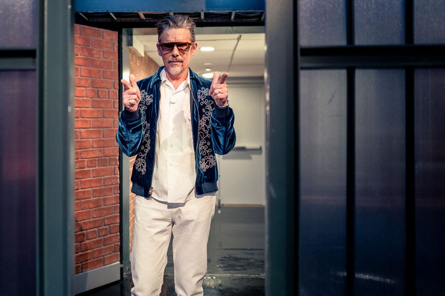 Ethan Hawke poses for photos outside a building