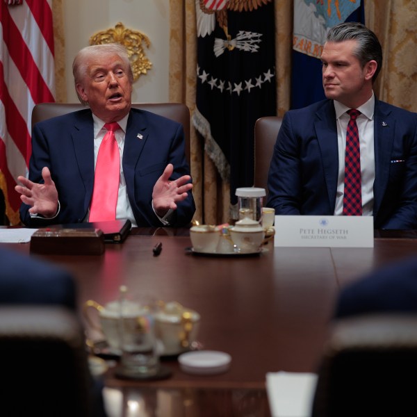 U.S. President Donald Trump (L) speaks as U.S. Secretary of War Pete Hegseth looks on during a meeting of his Cabinet in the Cabinet Room of the White House on December 02, 2025 in Washington, DC.