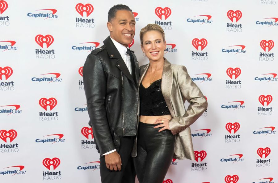 T.J. Holmes and Amy Robach pose for photos at an event