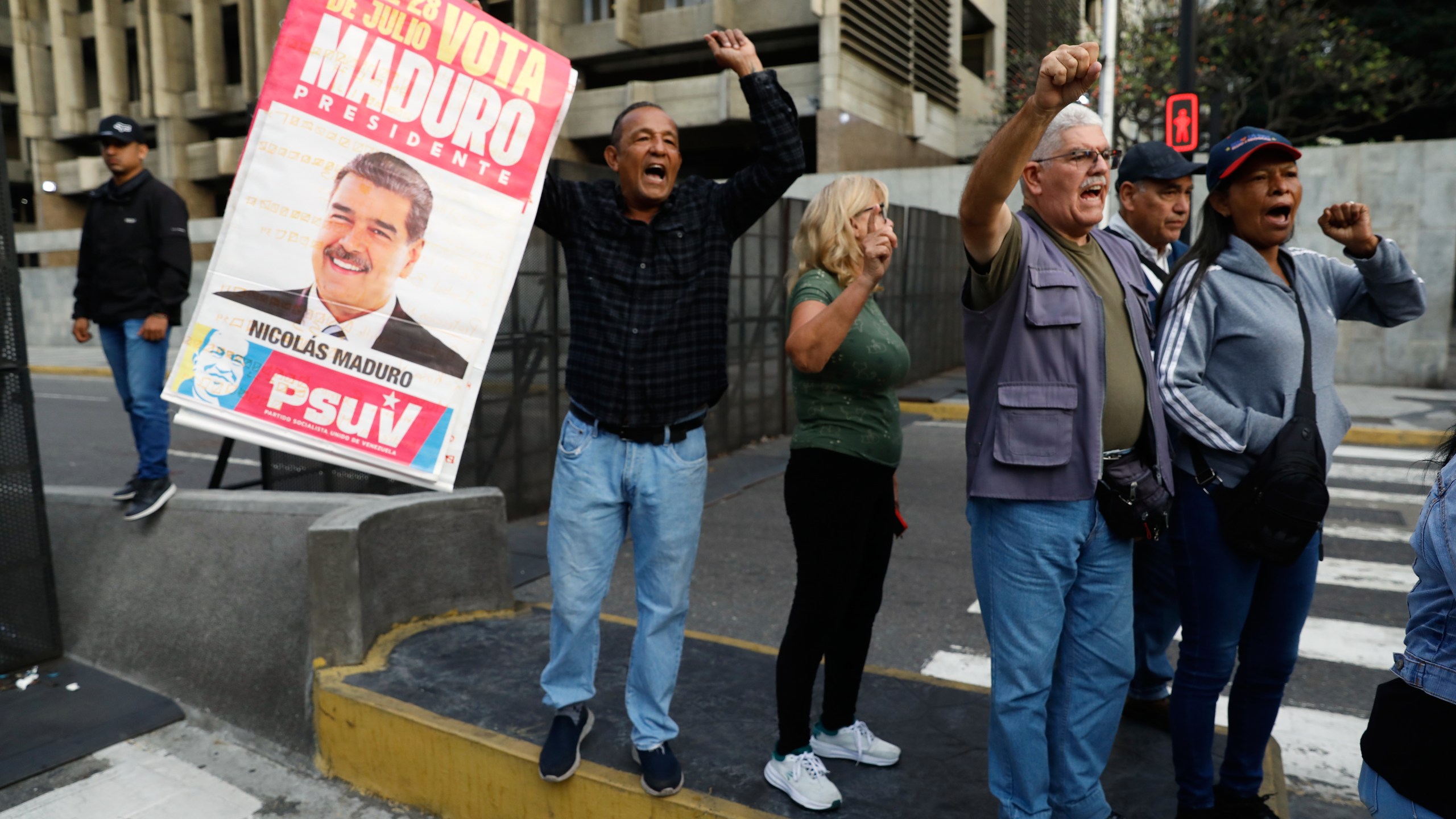 Supporters display a poster of Venezuelan President Nicolás Maduro in Caracas, Venezuela, Saturday, Jan. 3, 2026, after U.S. President Donald Trump announced Maduro had been captured and flown out of the country. (AP Photo/Cristian Hernandez)