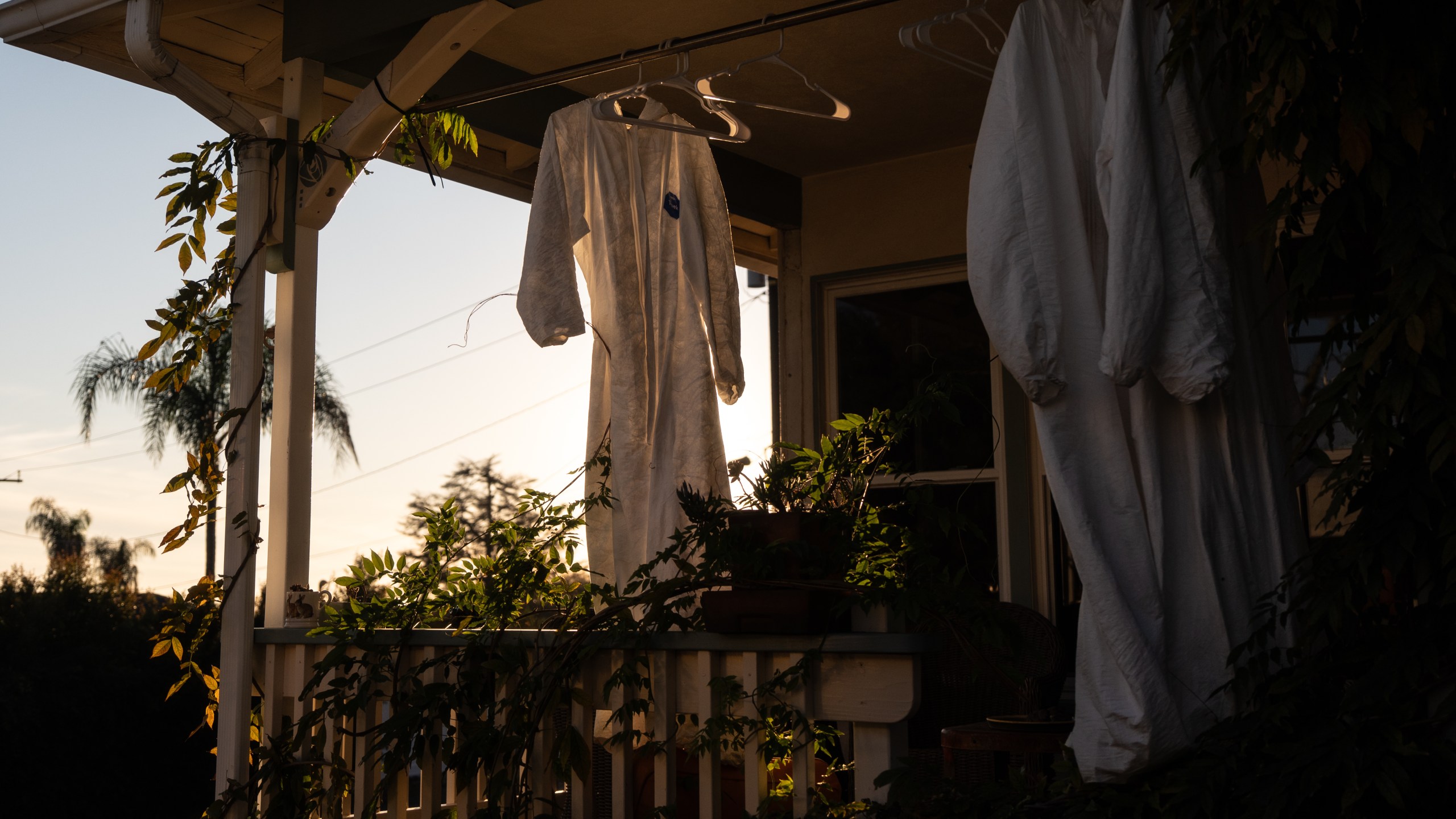 Protective suits hang outside a home that survived the Eaton Fire, Dec. 2, 2025, in Altadena, Calif., as cleaning crews remove fire debris from the property. (AP Photo/Jae C. Hong)