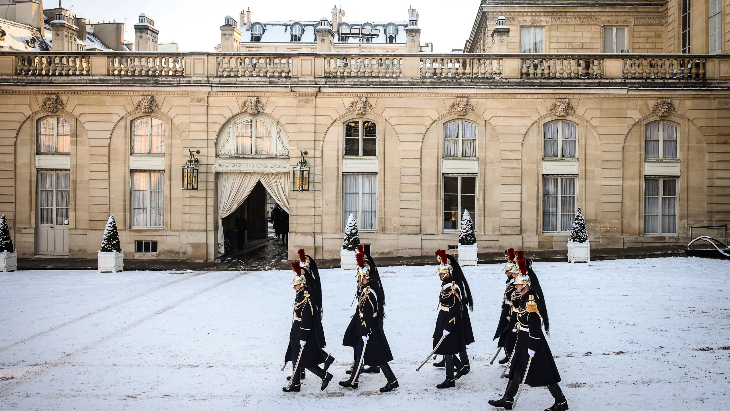 Republican Guards walk in the snow covered courtyard of the Elysee Palace in Paris, France, Tuesday, Jan. 6, 2026. (AP Photo/Thomas Padilla)