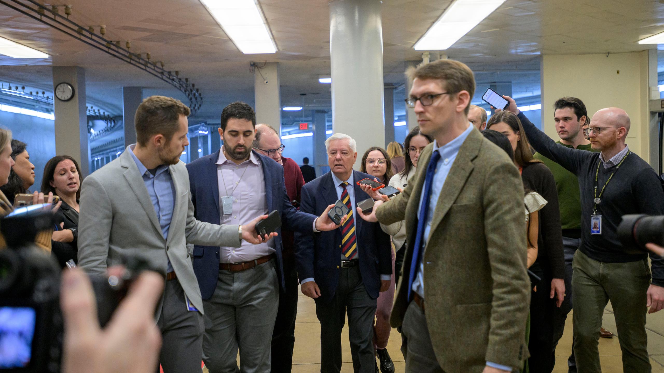 Sen. Lindsey Graham, R-S.C., center, talks with reporters in the Senate subway during a vote at the Capitol, Tuesday, Jan. 6, 2026, in Washington. (AP Photo/Rod Lamkey, Jr.)