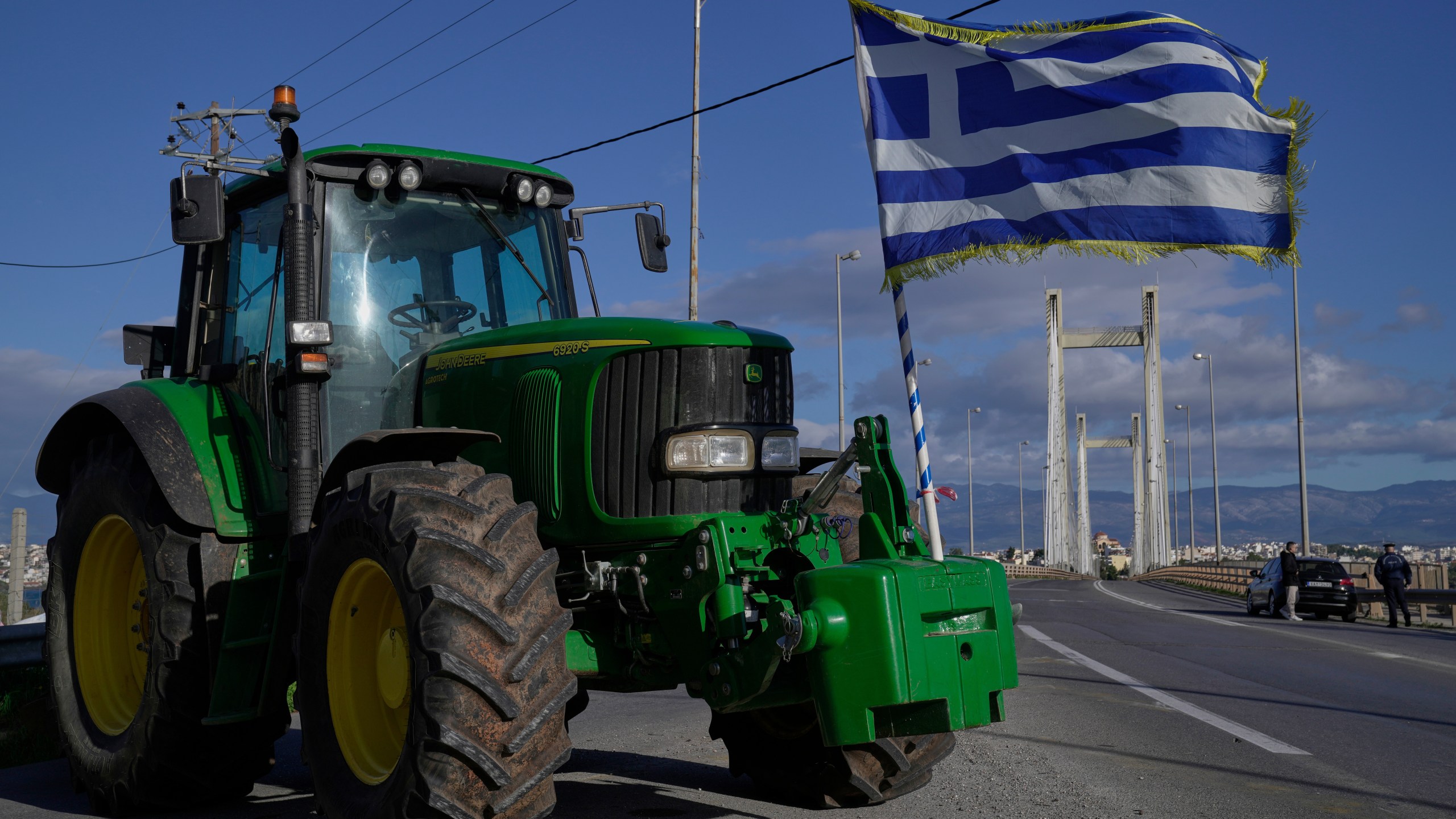A tractor with a Greek flag blocks the Chalkida Bridge as farmers protest over delays in European Union–backed agricultural subsidy payments, on Evia island, Greece, Thursday, Jan. 8, 2026. (AP Photo/Thanassis Stavrakis)
