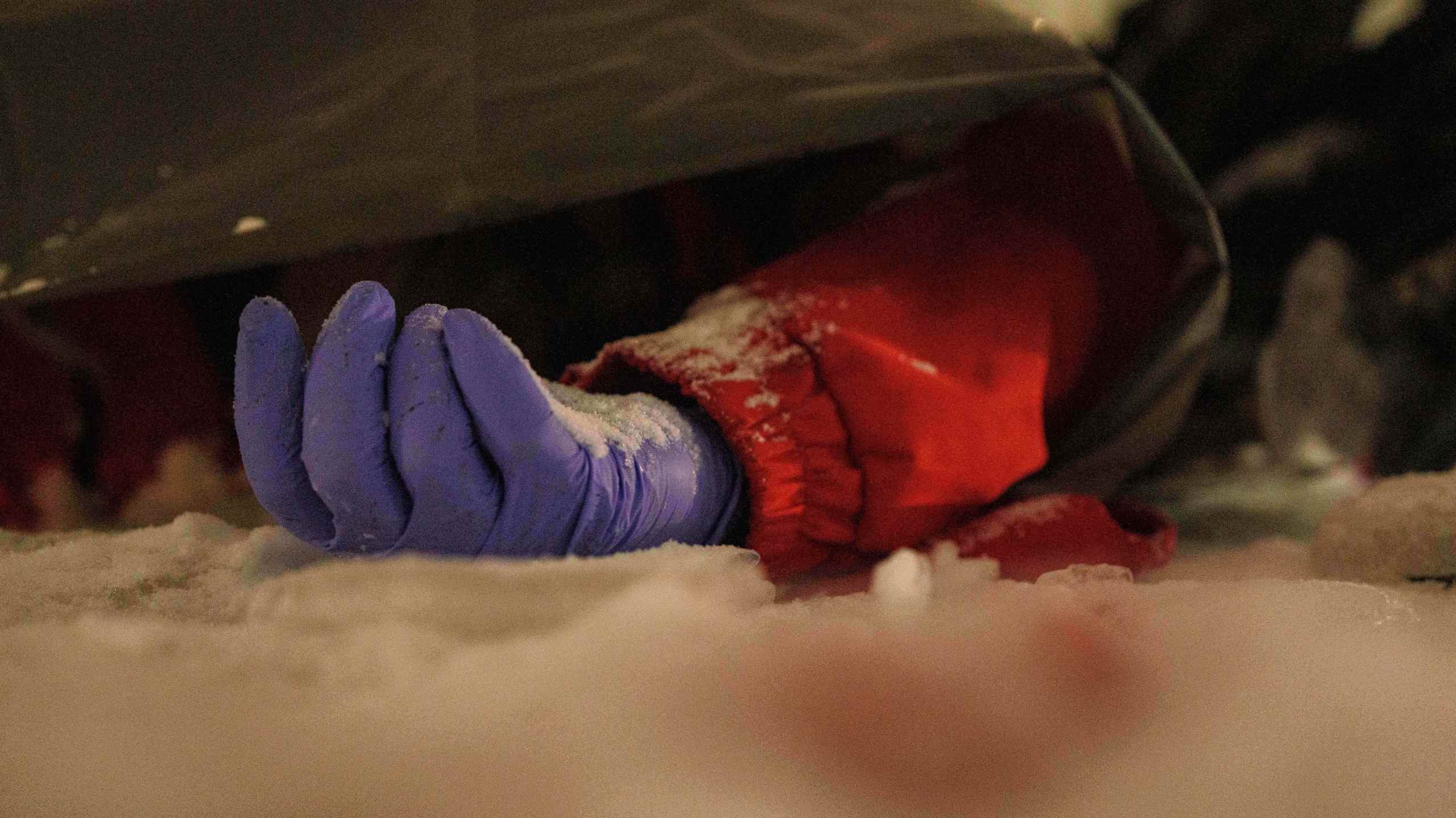 The body of a paramedic lies on the ground in the snow outside a residential building damaged by a Russian strike on Kyiv, Ukraine, Friday, Jan. 9, 2026. (AP Photo/Evgeniy Maloletka)