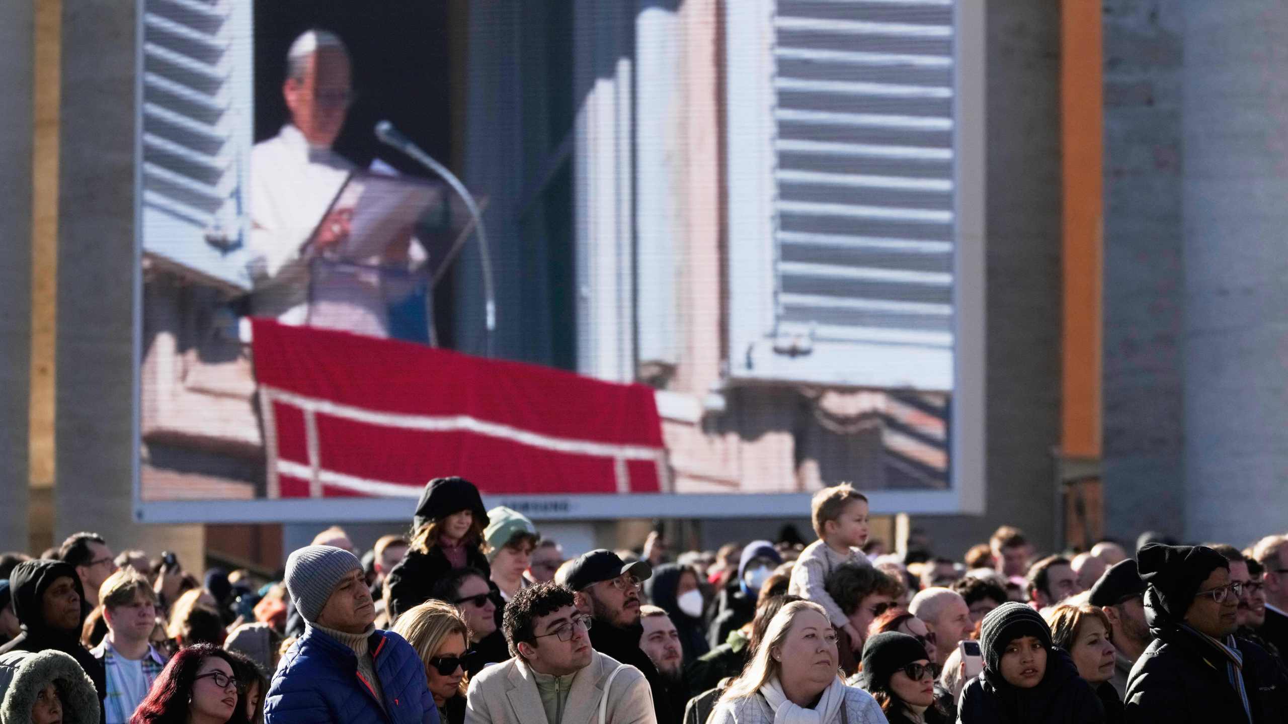 Faithful listen to Pope Leo XIV's Angelus noon prayer in St. Peter's Square at the Vatican, Sunday, Jan. 11, 2026. (AP Photo/Gregorio Borgia)