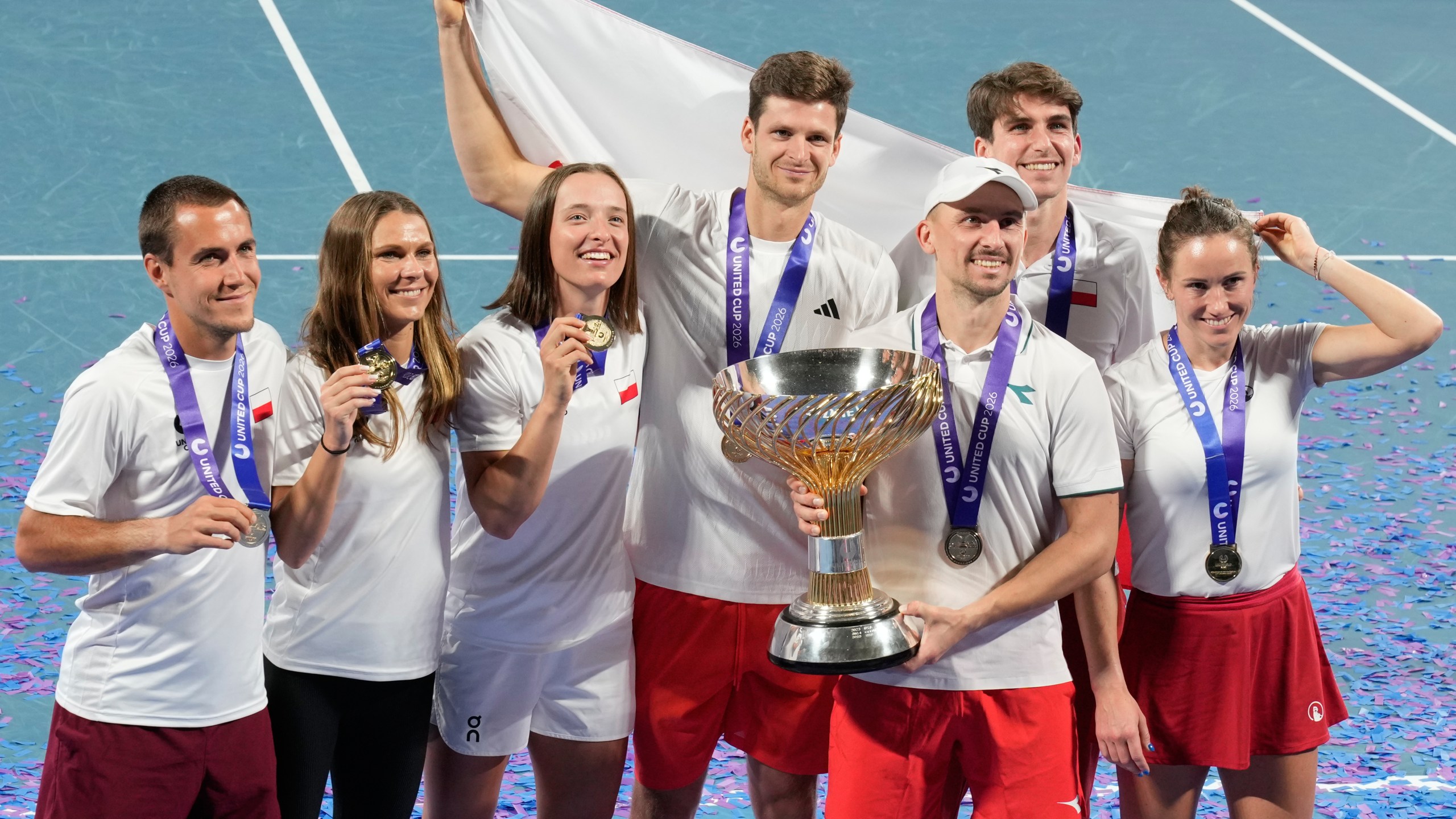 Teammembers from Poland celebrate with their trophy after defeating Switzerland in the final at the United Cup tennis tournament in Sydney, Monday, Jan. 12, 2026. (AP Photo/Rick Rycroft)