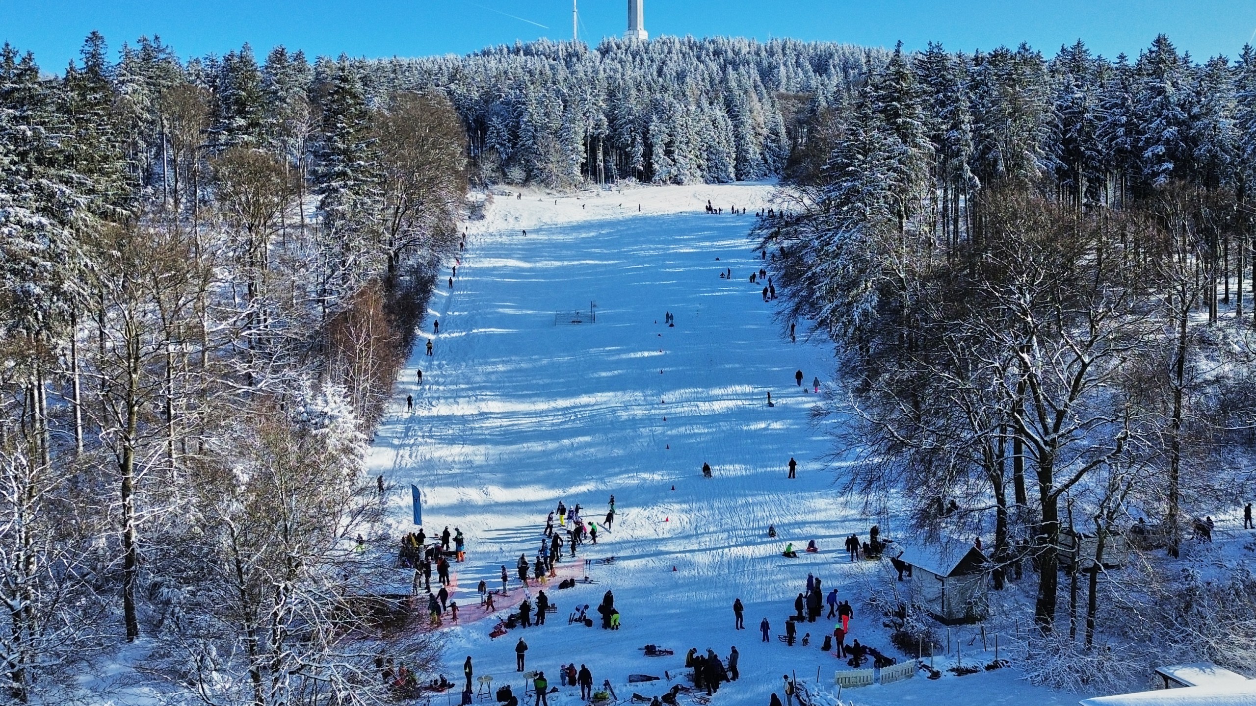 People ski and sled on a hill with the last call ski lift in Oberreifenberg in the Taunus region near Frankfurt, Germany, Sunday, Jan. 11, 2026. (AP Photo/Michael Probst)