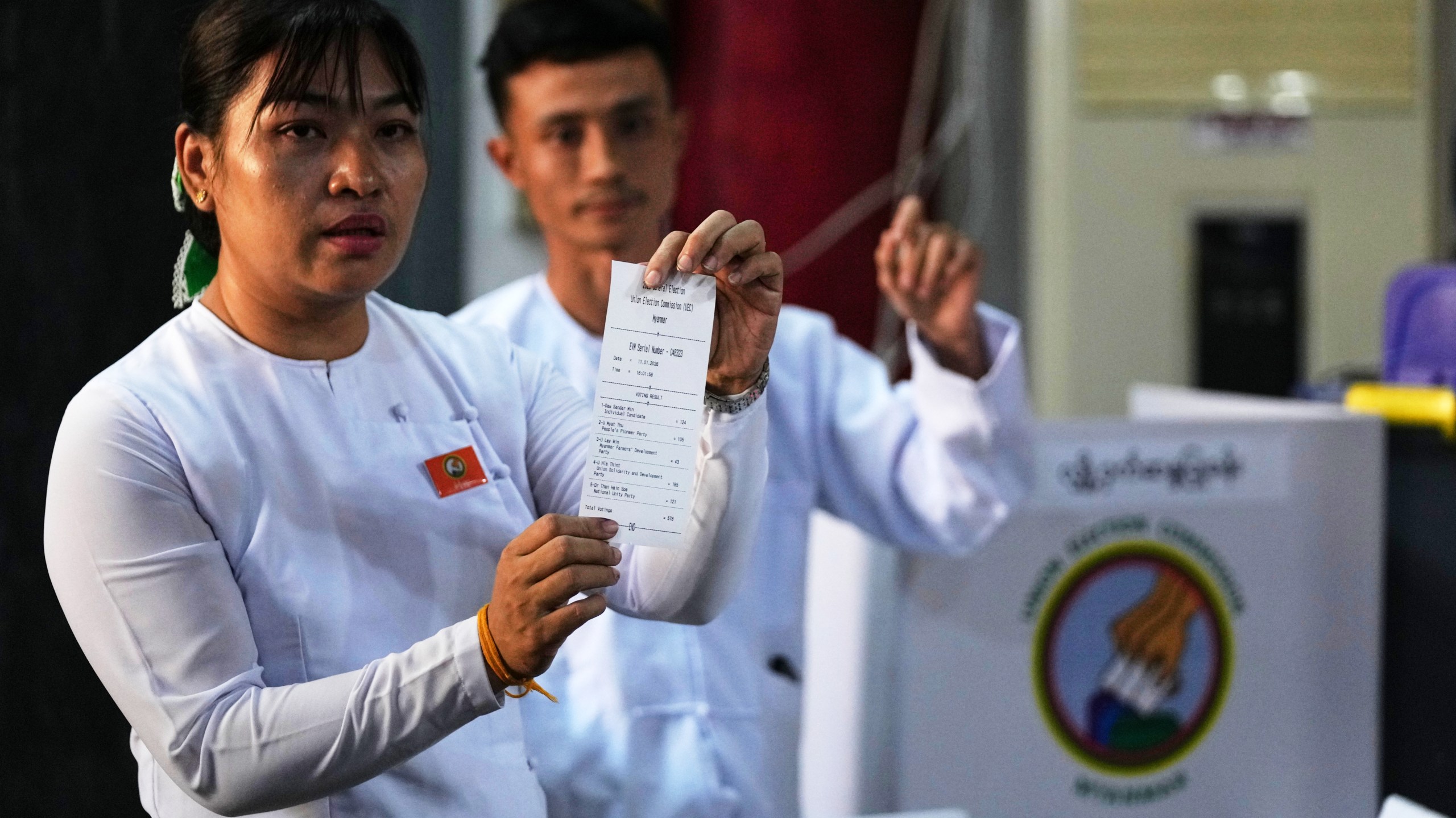 An official of the Union Election Commission shows a slip as they count ballots at a polling station during the second phase of general election in Yangon, Myanmar, Sunday, Jan. 11, 2026. (AP Photo/Thein Zaw)