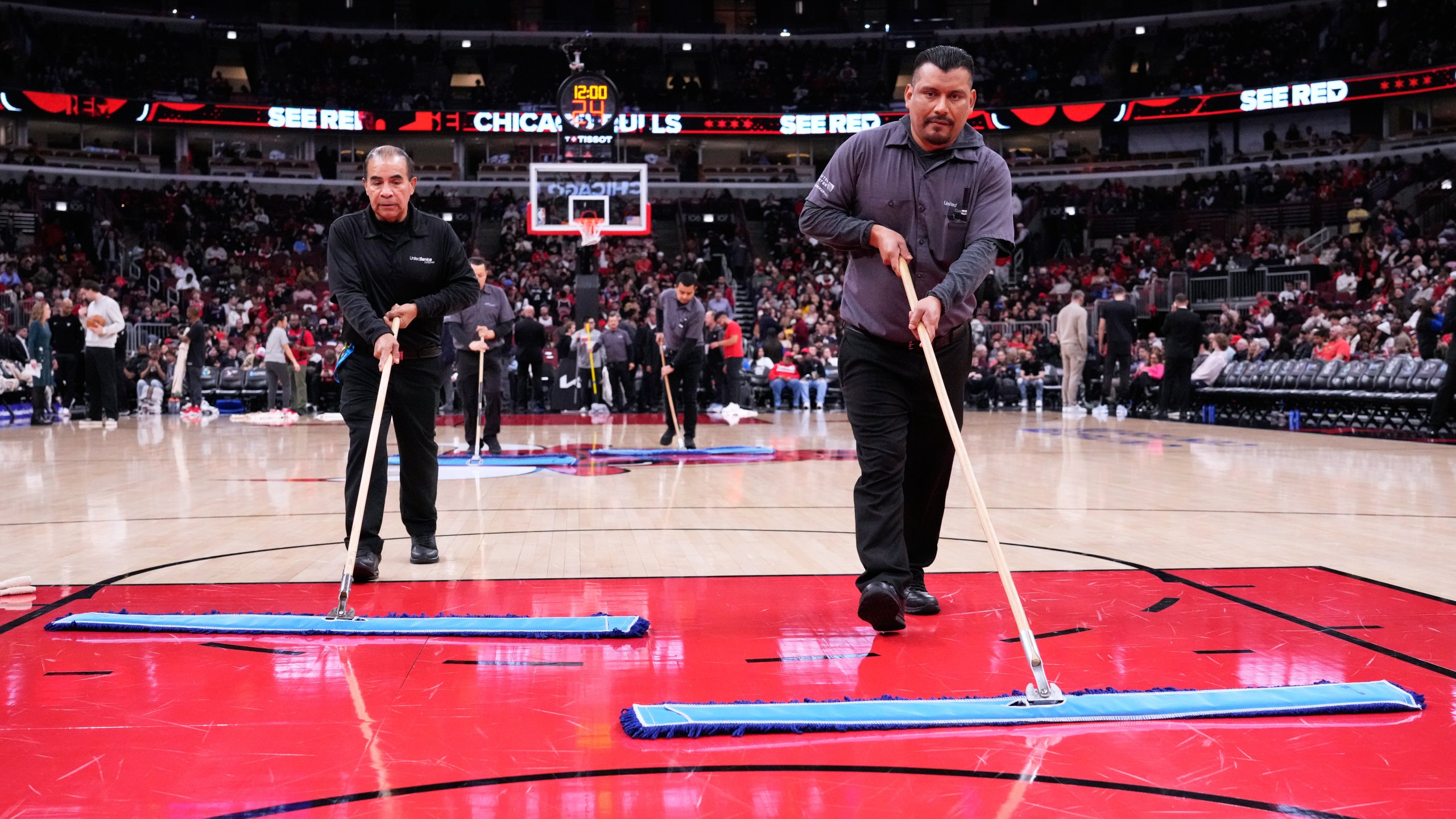 United Center employees try to dry the court before an NBA basketball game between the Miami Heat and the Chicago Bulls in Chicago, Thursday, Jan. 8, 2026. (AP Photo/Nam Y. Huh)