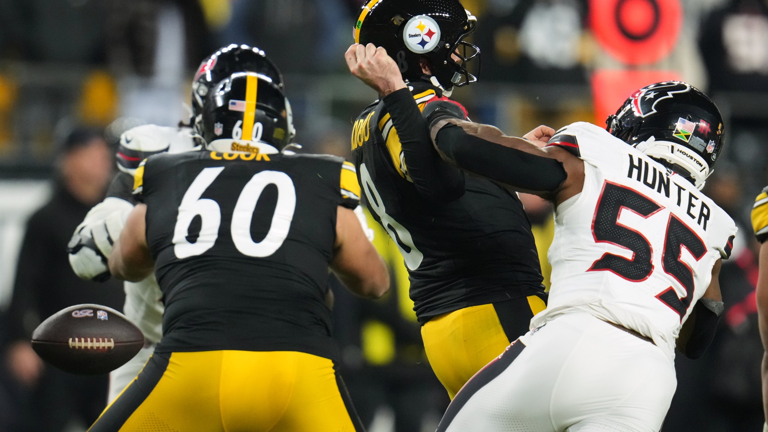 Pittsburgh Steelers quarterback Aaron Rodgers (8) loses possession of the ball while being tackled by Houston Texans defensive end Danielle Hunter (55) during the second half of an NFL wild-card playoff football game, Monday, Jan. 12, 2026, in Pittsburgh. (AP Photo/Gene J. Puskar)