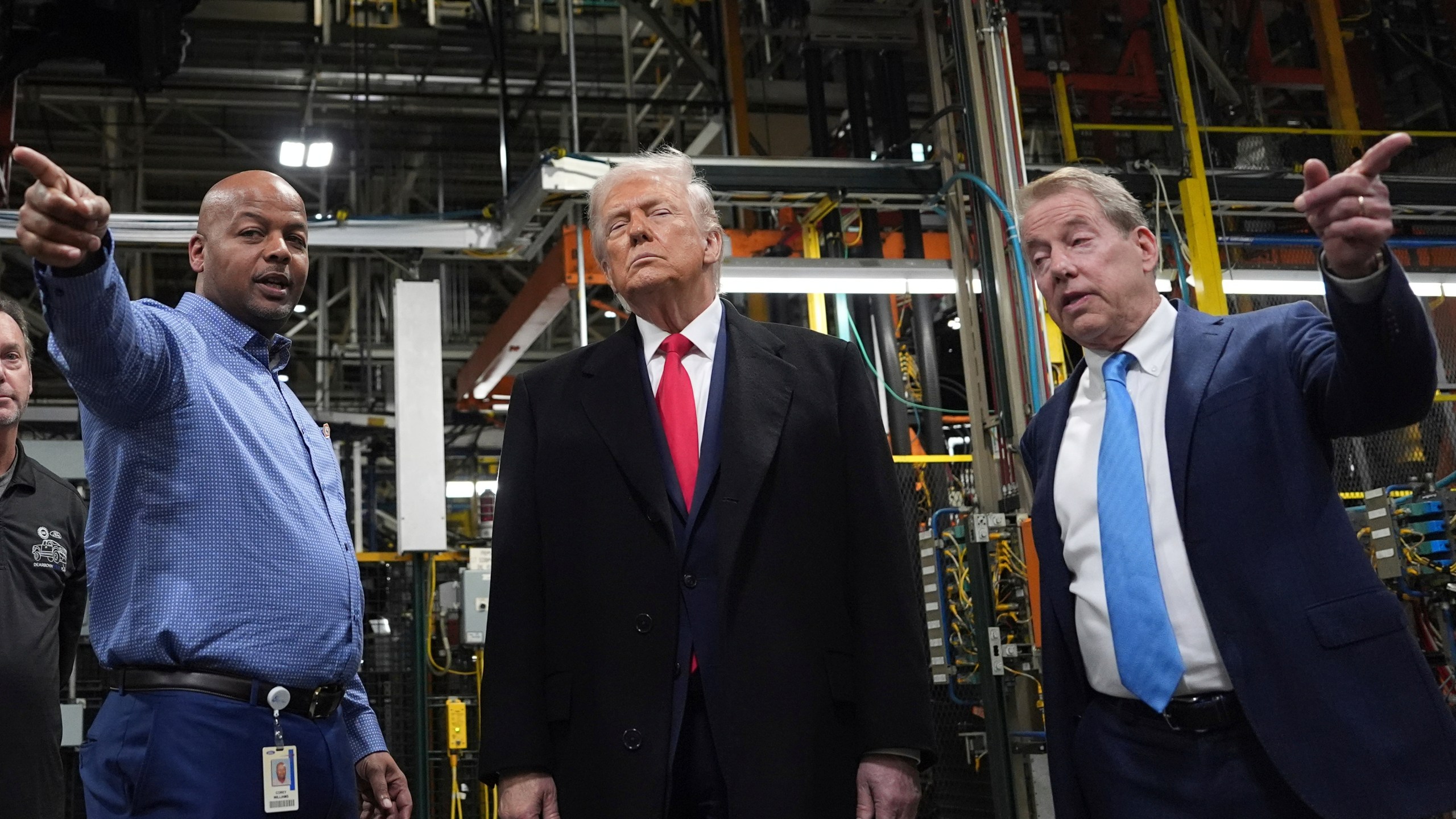 President Donald Trump listens to Corey Williams, Ford River Rouge Plant Manager, left, and Bill Ford, Executive Chairman of Ford, during a tour of the Ford River Rogue complex, Tuesday, Jan. 13, 2026, in Dearborn, Mich. (AP Photo/Evan Vucci)