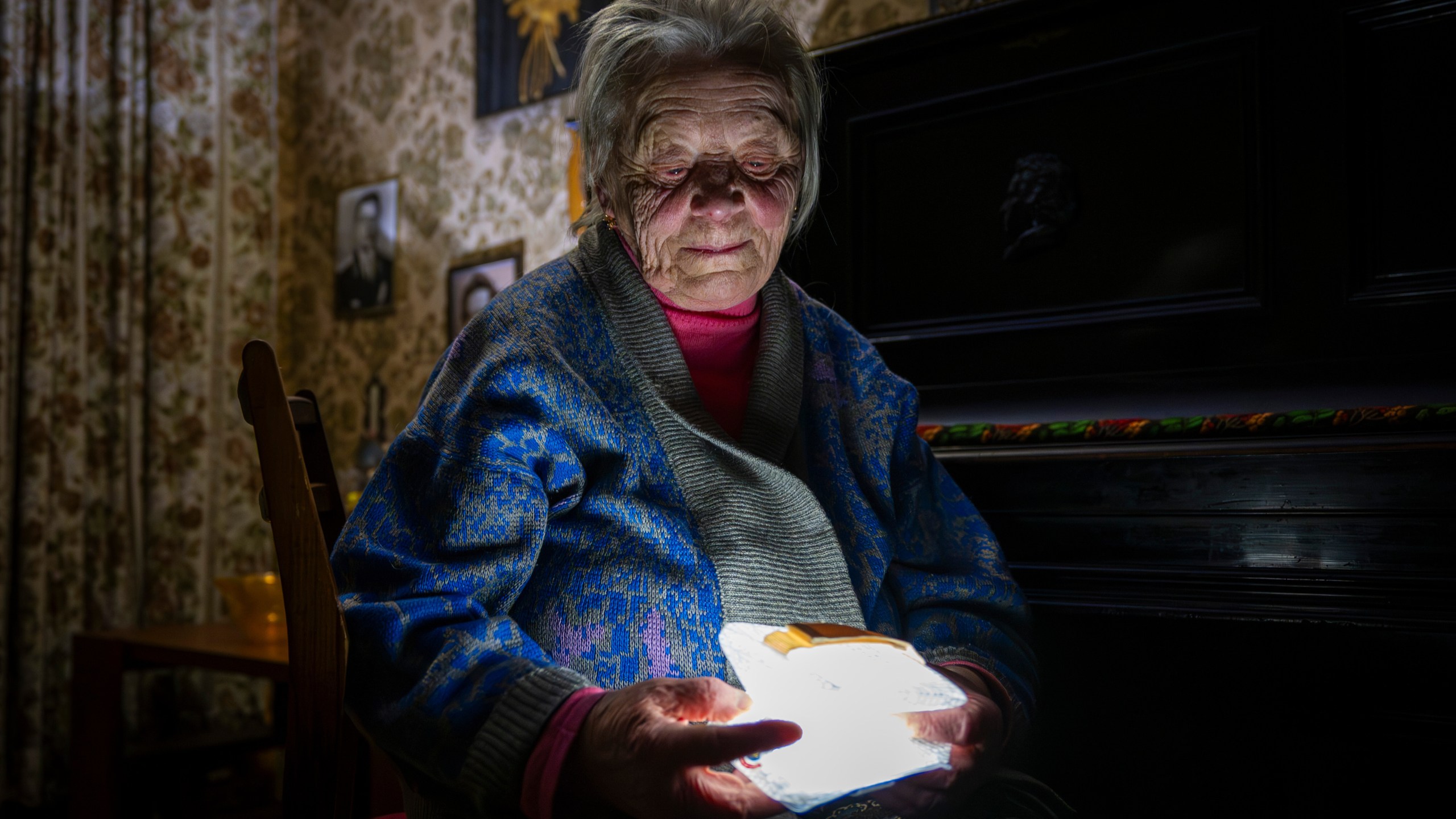 Raisa Derhachova holds a homemade flashlight during a power outage caused by regular Russian air strikes on the country's energy facilities in Kyiv, Ukraine, Tuesday, Jan. 13, 2026. (AP Photo/Dan Bashakov)