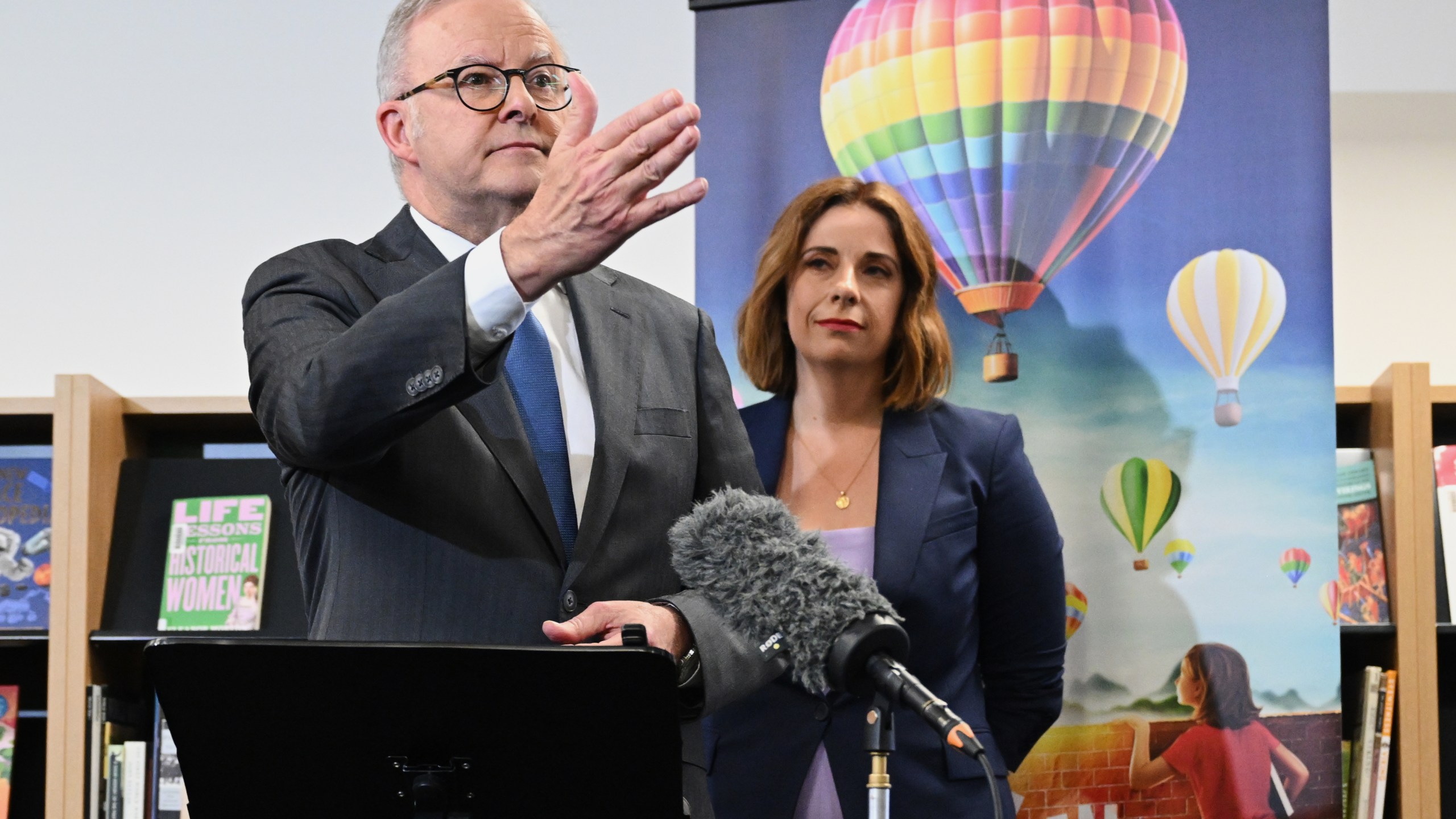 Australian Prime Minister Anthony Albanese, left, and Australian Communications Minister Anika Wells speak to the media during a visit to St John Paul II College in Canberra, Australia, on Dec. 11, 2025. (Lukas Coch/AAP Image via AP)