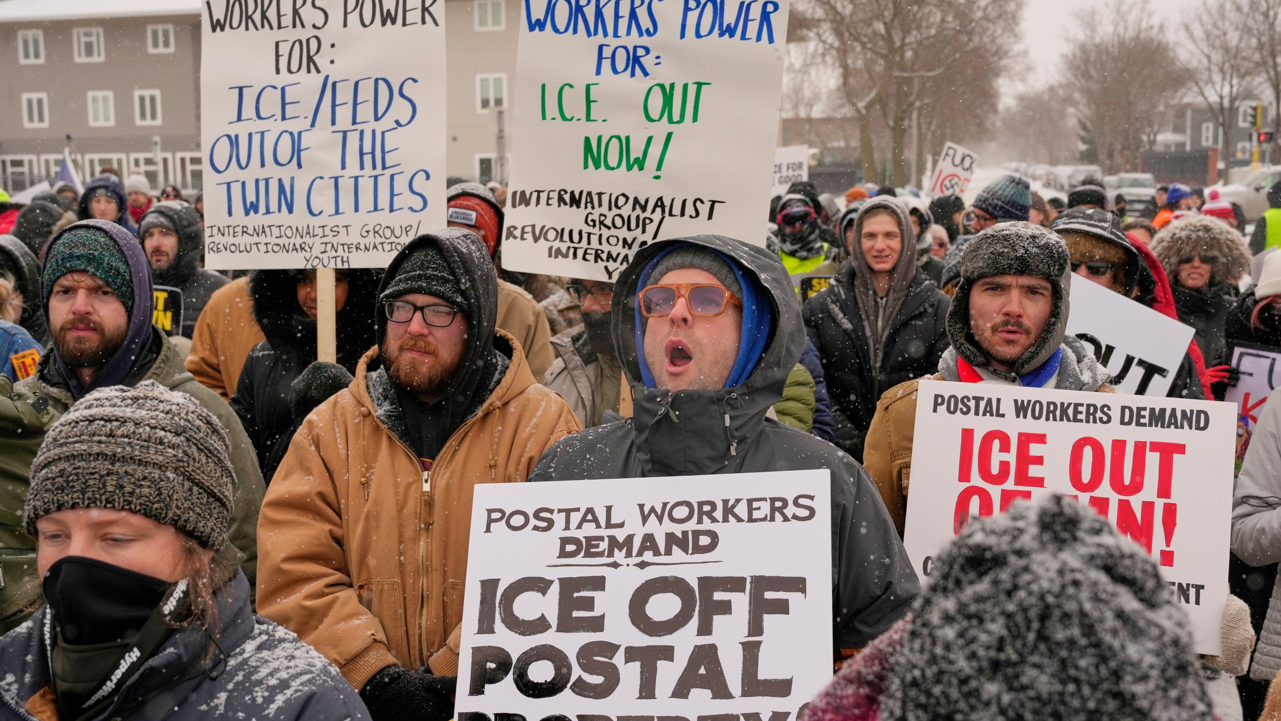 People march and gather near the post office during a protest, Sunday, Jan. 18, 2026, in Minneapolis. (AP Photo/Yuki Iwamura)
