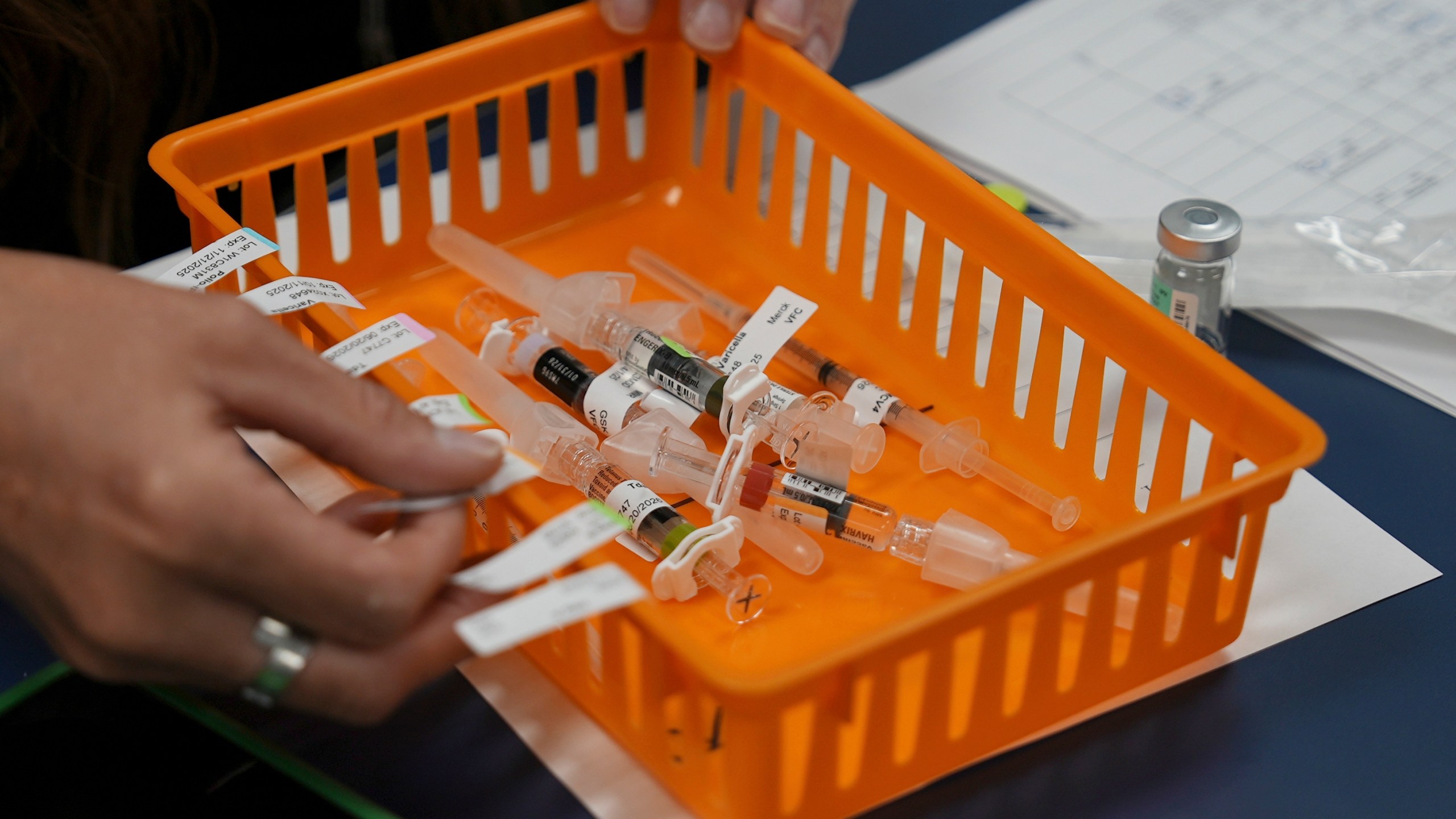 An orange basket with vaccines in it