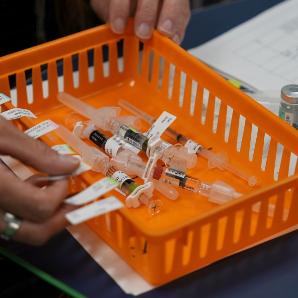 An orange basket with vaccines in it