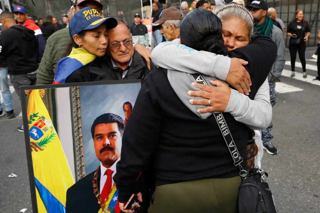 Supporters of Venezuelan President Nicolás Maduro embrace in downtown Caracas, Venezuela, Saturday, Jan. 3, 2026, after U.S. President Donald Trump announced that Maduro had been captured and flown out of the country. 