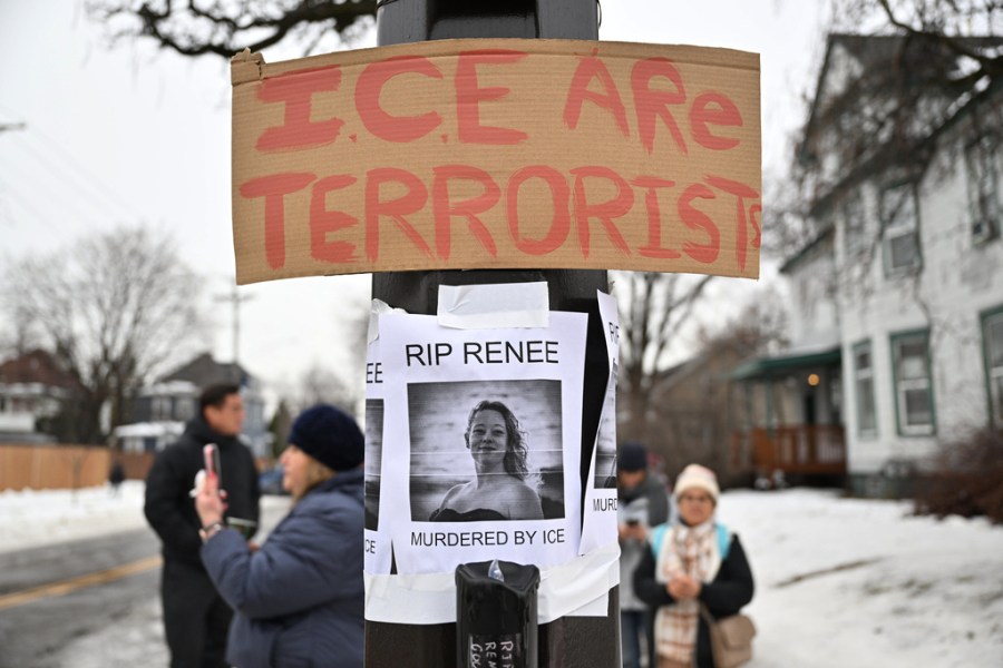 A sign reading "ICE are terrorists" is taped above a photo of Renee Good. 