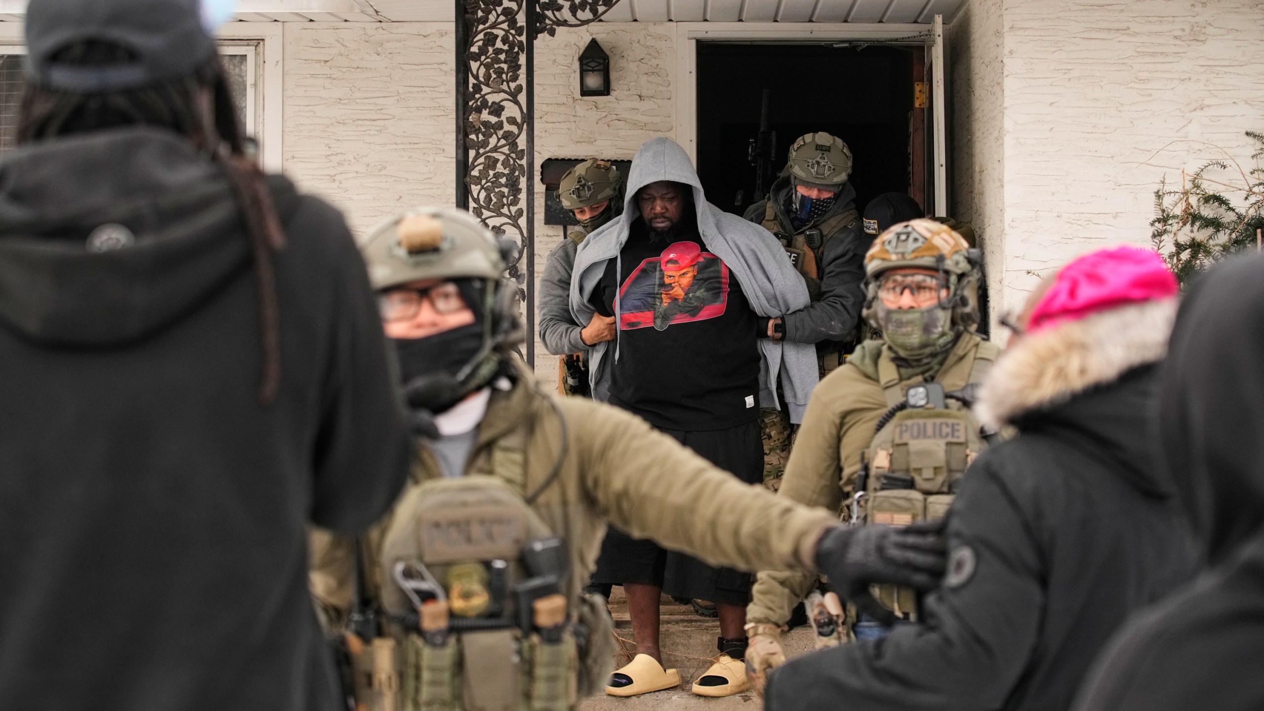 Man being detained by ICE agents at a house in Minnesota