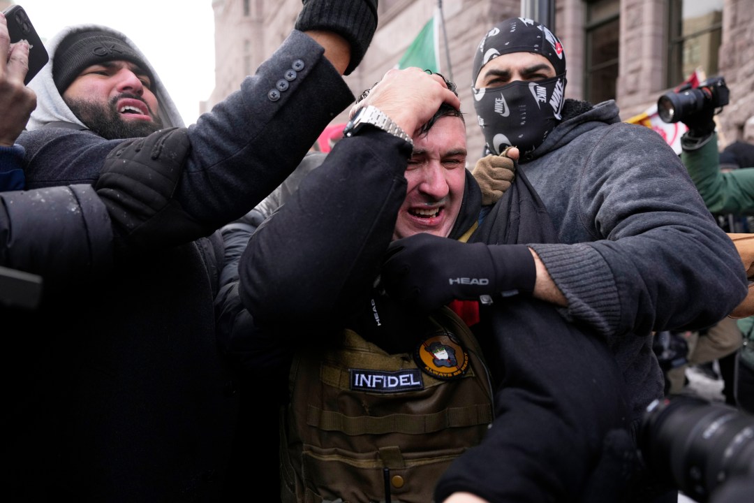 Demonstrator holds his head, as if injured