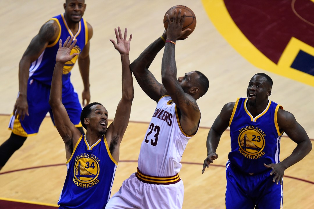 LeBron James goes up for a layup past Shaun Livingston and Draymond Green