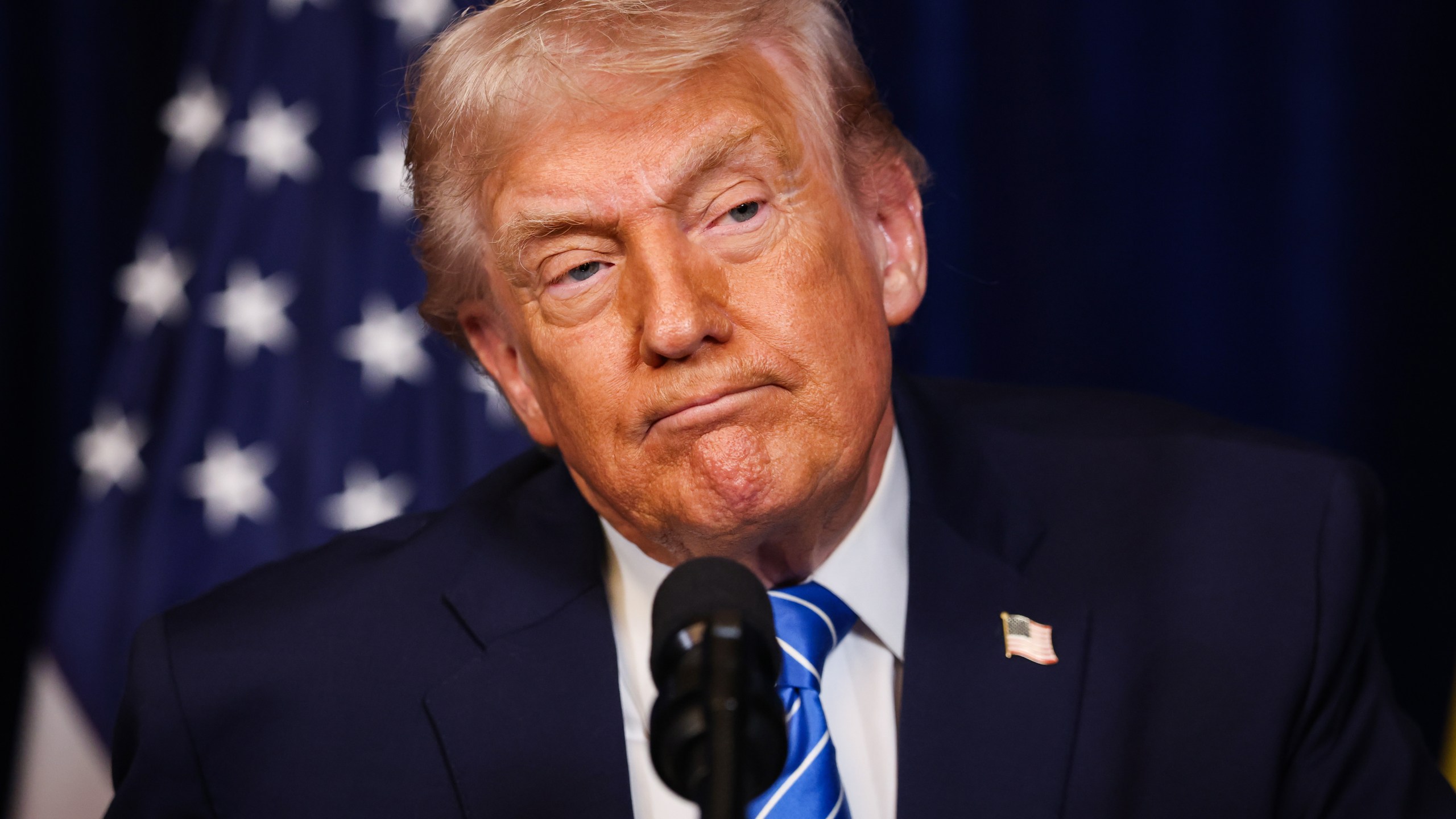 Donald Trump pictured listening during a press conference.