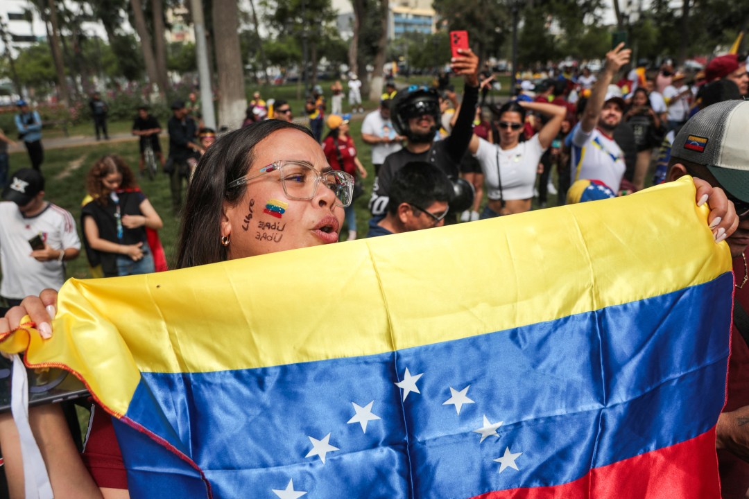 A Venezuelan woman living in Peru celebrates with a national flag at the Miguel de Cervantes park, near the Venezuelan Embassy in Lima on January 3, 2026, after US forces captured Venezuelan leader Nicolas Maduro. President Donald Trump said Saturday that US forces had captured Venezuela's leader Nicolas Maduro after bombing the capital Caracas and other cities in a dramatic climax to a months-long standoff between Trump and his Venezuelan arch-foe.