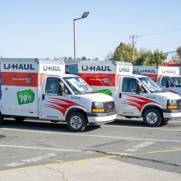 Row of U-Haul moving trucks parked in rental lot on a clear day, Concord, California, December 11, 2025.