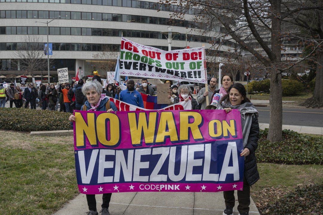 Demonstrators hold a sign reading "No War on Venezuela"