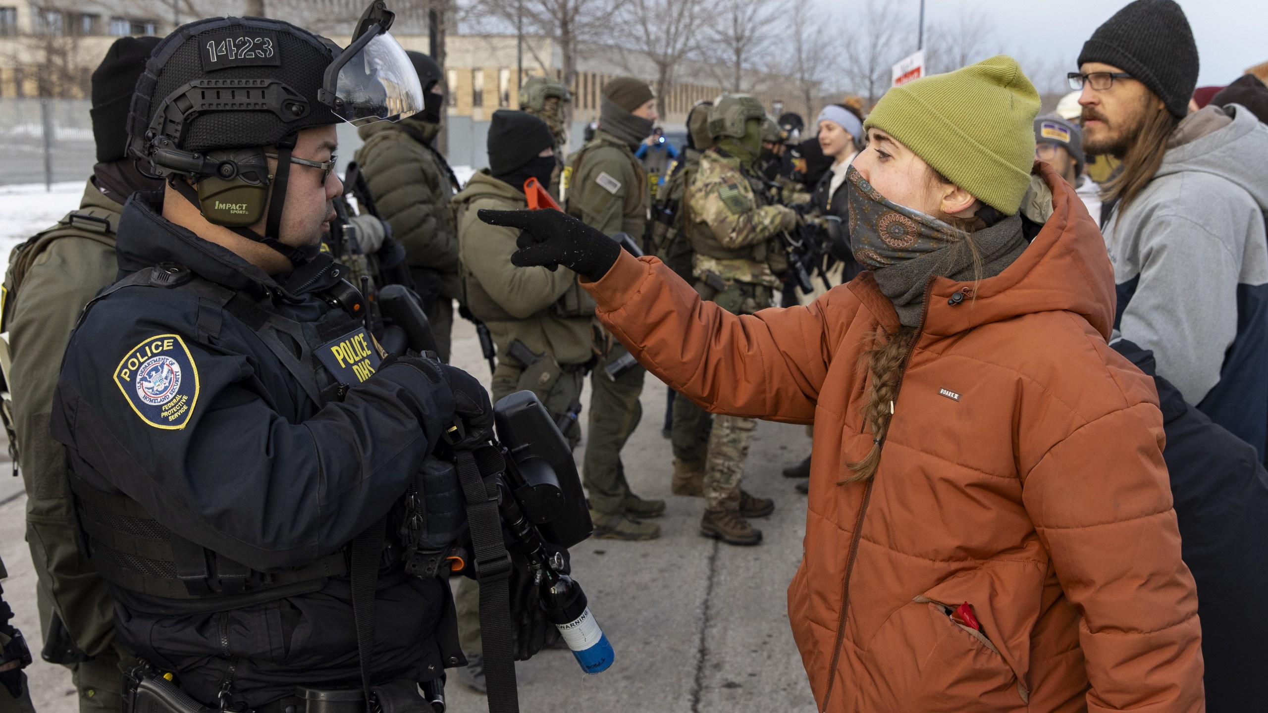 A protestor points at U.S. Immigration and Customs Enforcement officer