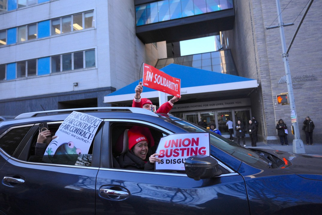 Car drives by striking nurses with signs of support