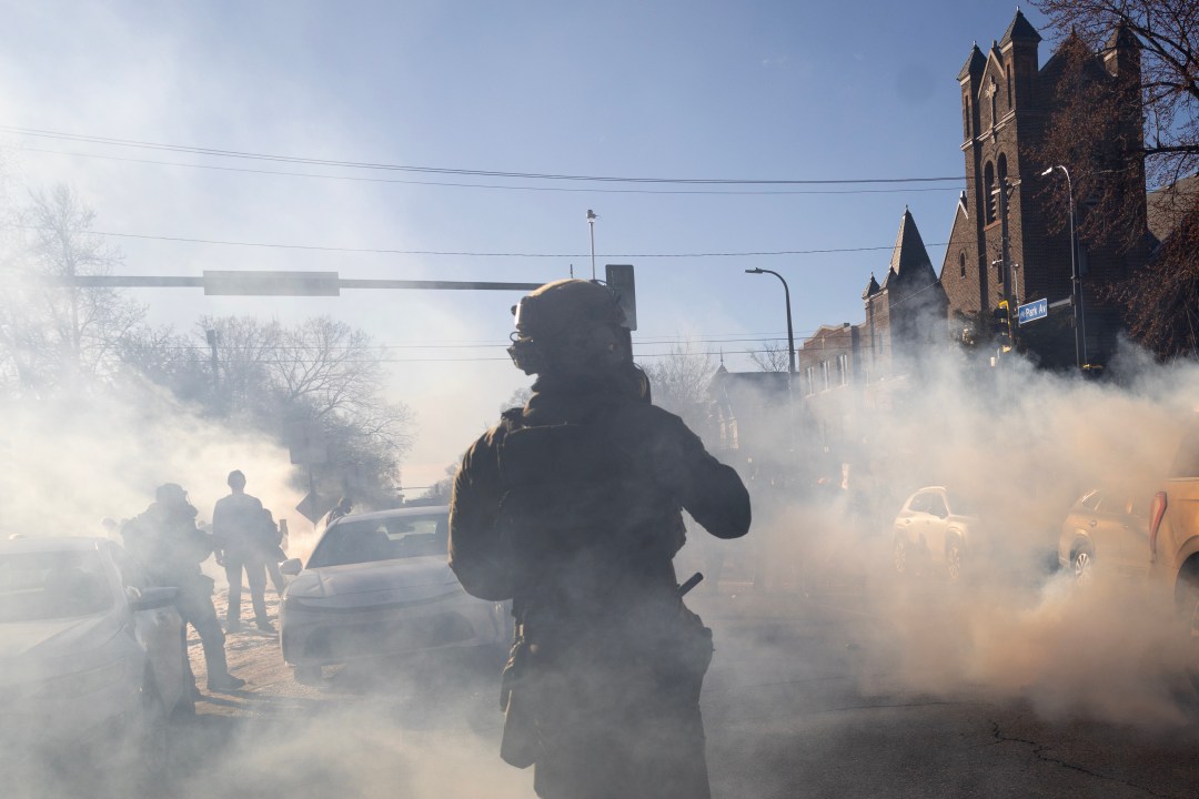 Federal immigration officer surrounded by tear gas