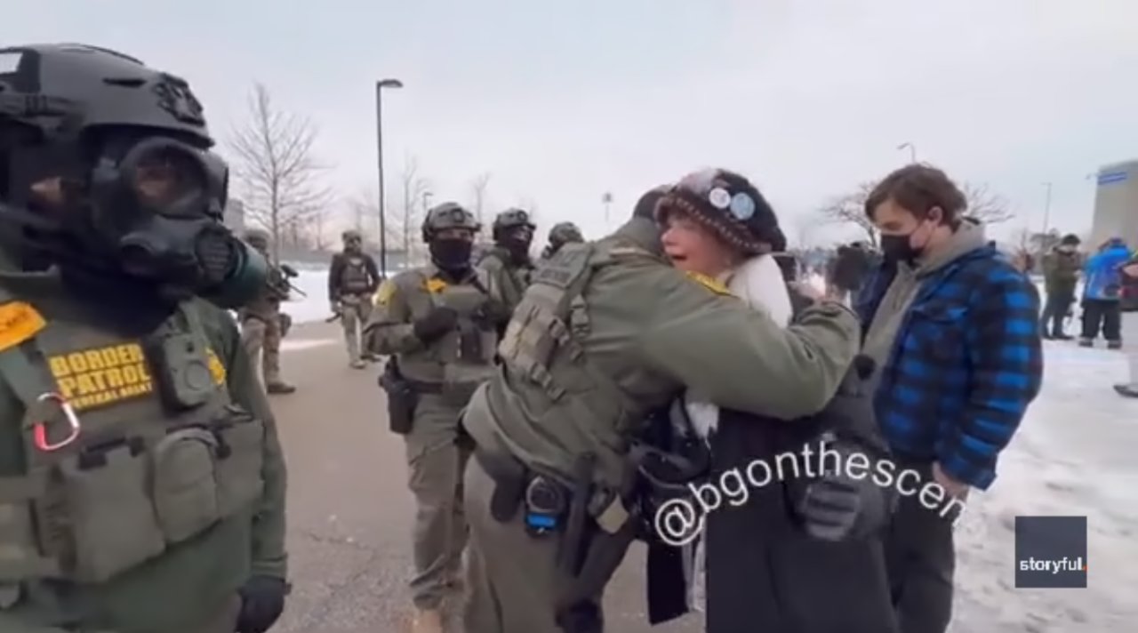 A Border Patrol agent hugs a protester outside an ICE facility.